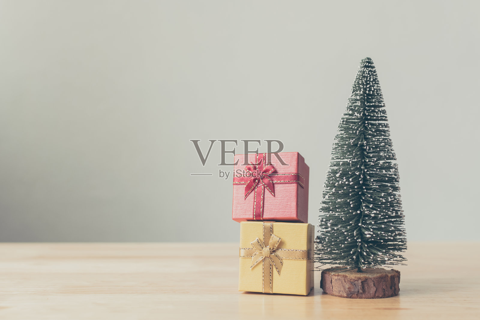 圣诞树和礼盒红色，黄色的木桌与白色的墙背景，圣诞节日庆祝和节礼日概念，复制空间照片摄影图片