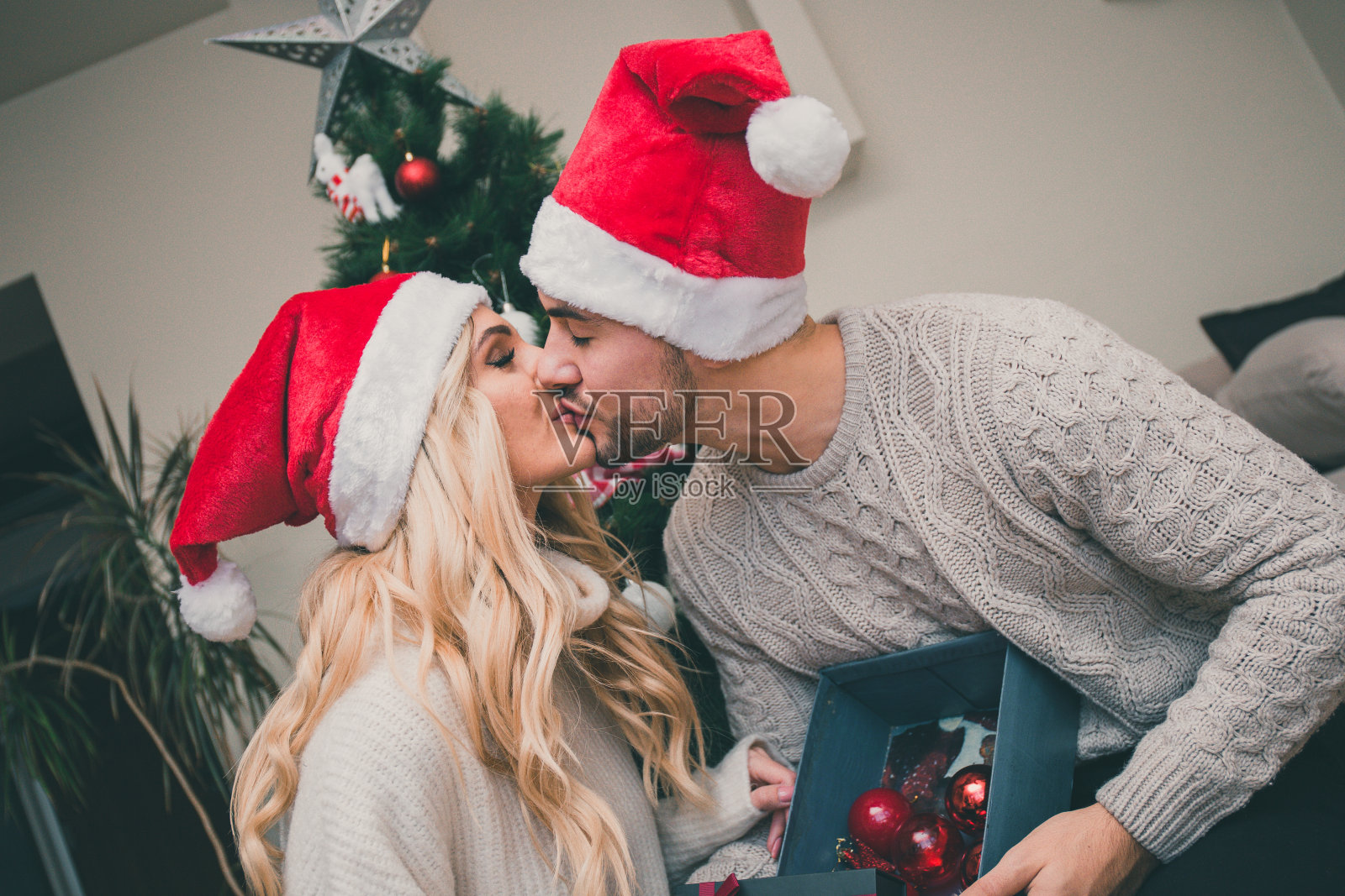 戴着圣诞帽接吻的情侣照片摄影图片
