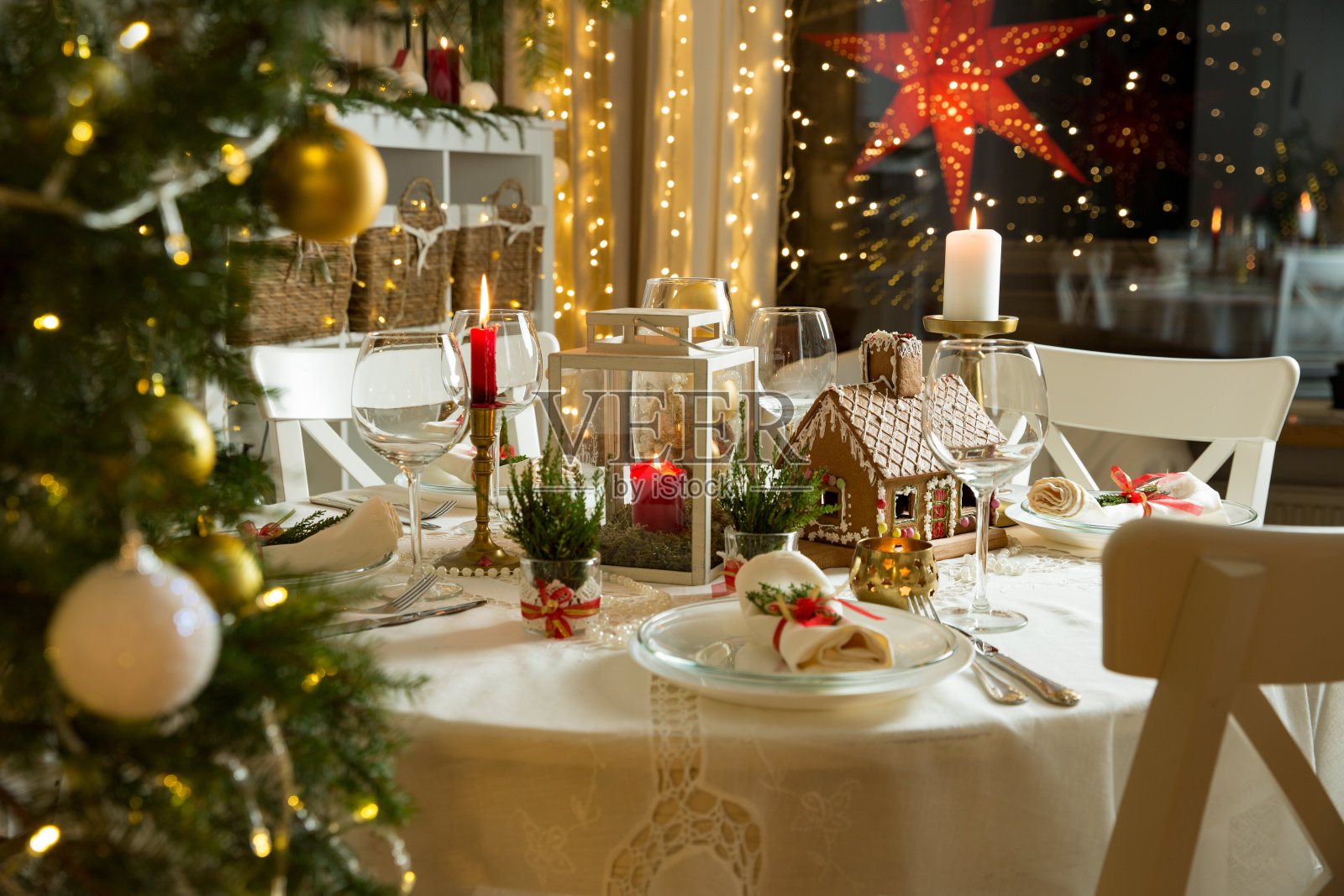 漂亮的餐桌上有圣诞装饰品，蜡烛和灯笼照片摄影图片