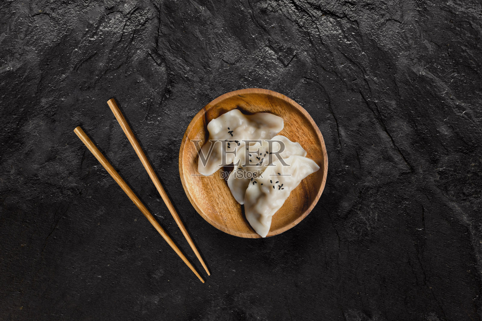 黑色石板上的亚洲水饺。照片摄影图片
