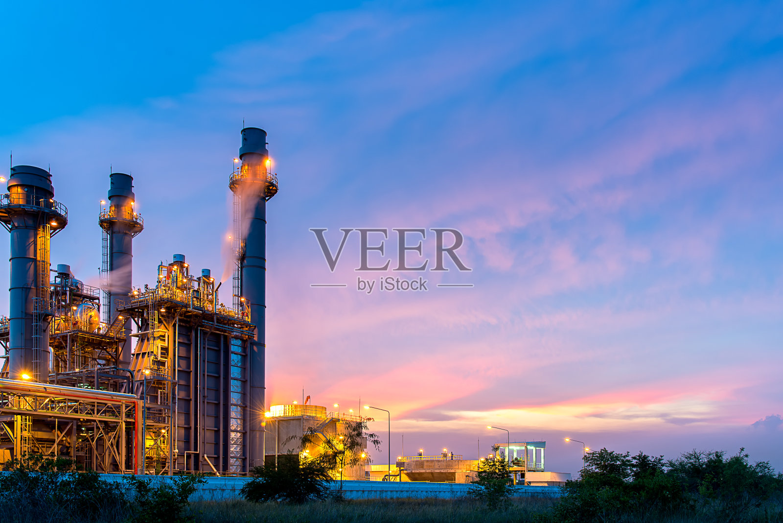 炼油厂，石油和能源工厂在黄昏与天空背景。产业的概念照片摄影图片