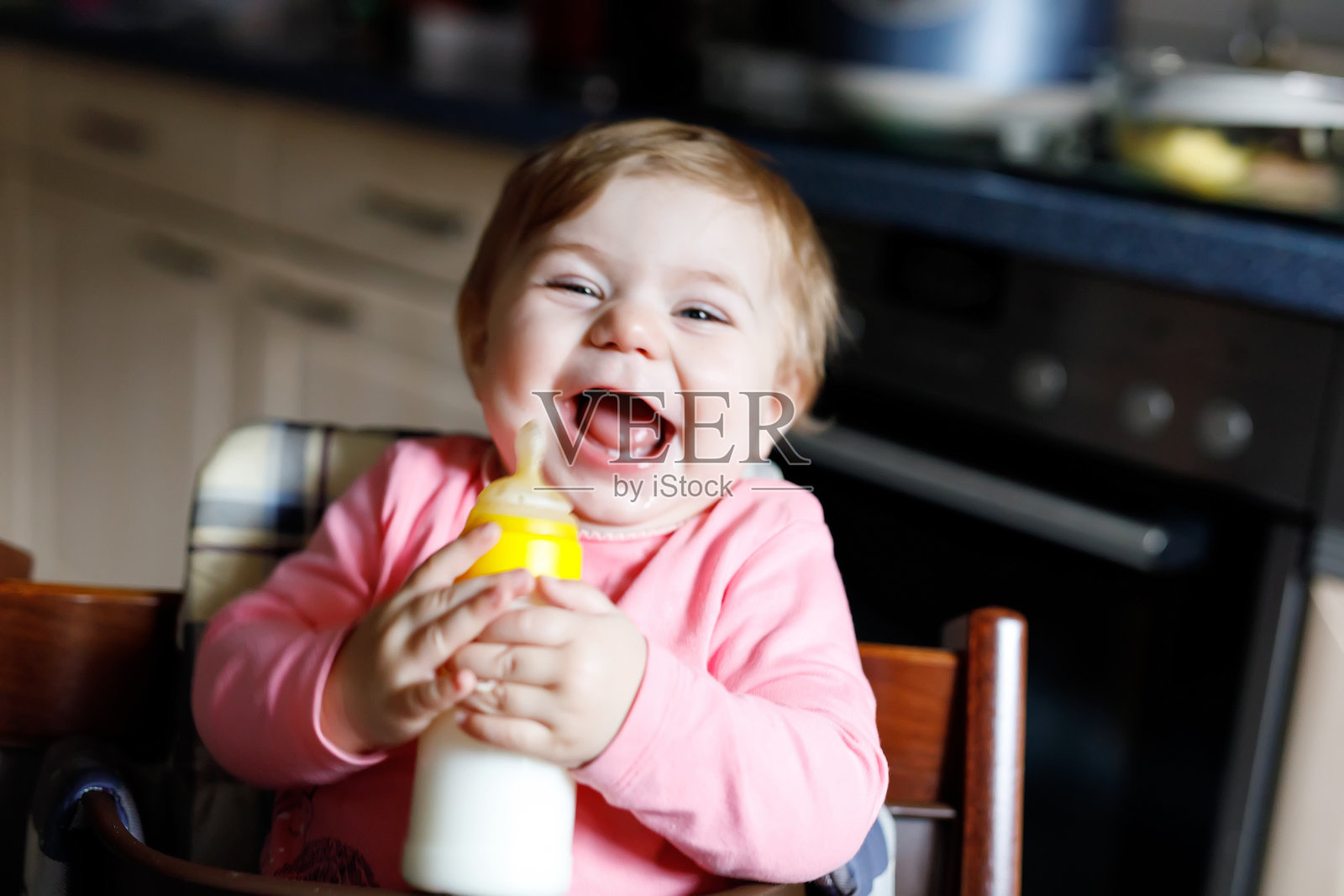可爱可爱的初生女婴抱着奶瓶喝配方奶照片摄影图片
