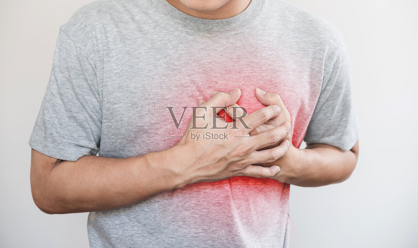 一个男人摸着自己的心脏，用红色标出心脏病发作、心力衰竭等心脏病照片摄影图片