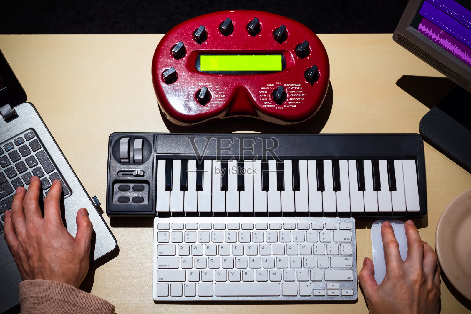 男性作曲家使用电脑，MIDI键盘和录音室设备制作歌曲和在桌子上为后期制作或电影配乐的声音设计照片摄影图片