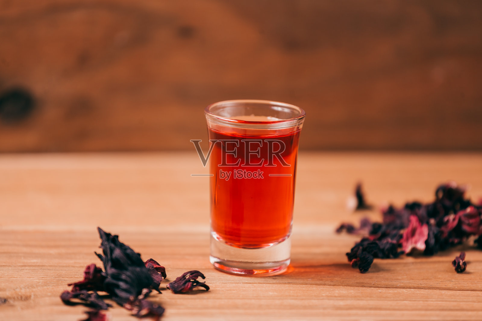 红热的木槿茶，放在一张木桌上的玻璃杯里照片摄影图片