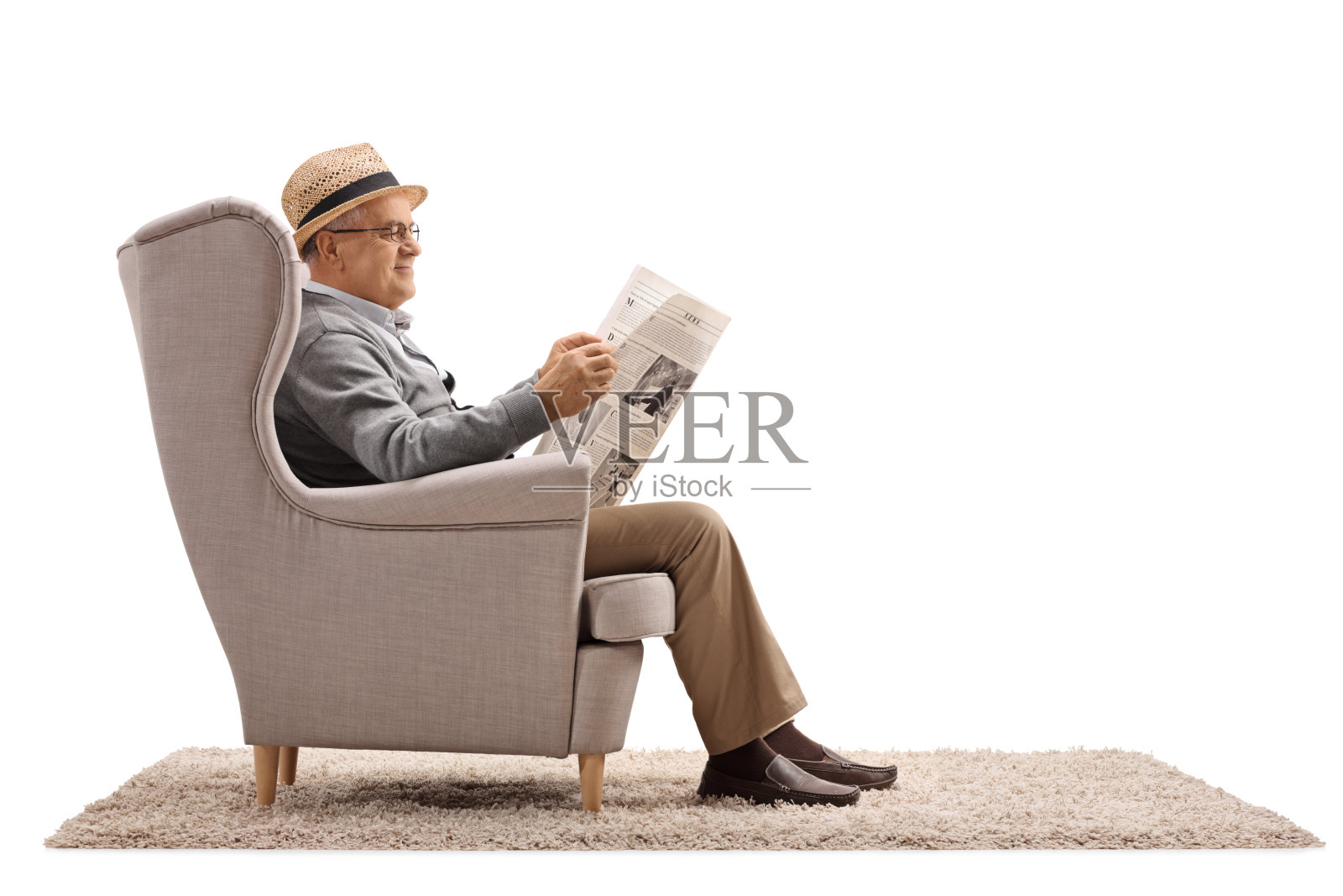 一个成熟的男人坐在扶手椅上看报纸照片摄影图片