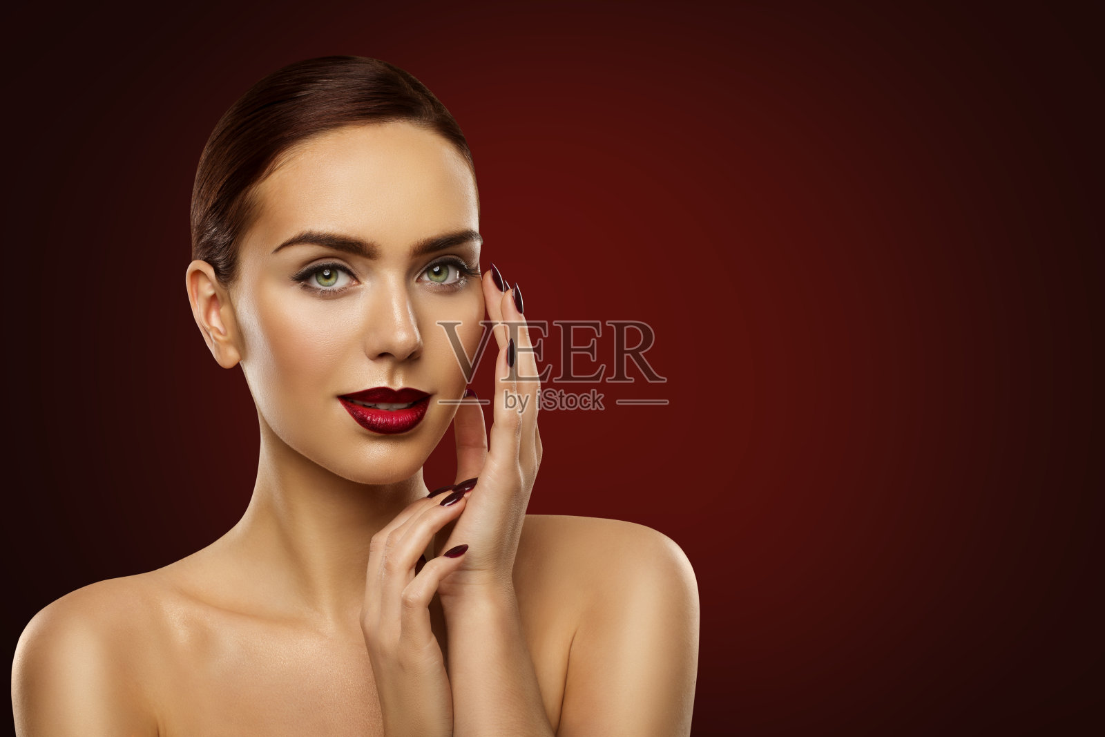 女人美容化妆，时尚模特深红色指甲和脸化妆，女孩在红色背景照片摄影图片