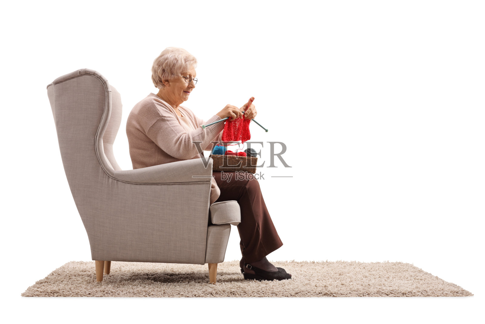 坐在扶手椅上织毛衣的老妇人照片摄影图片