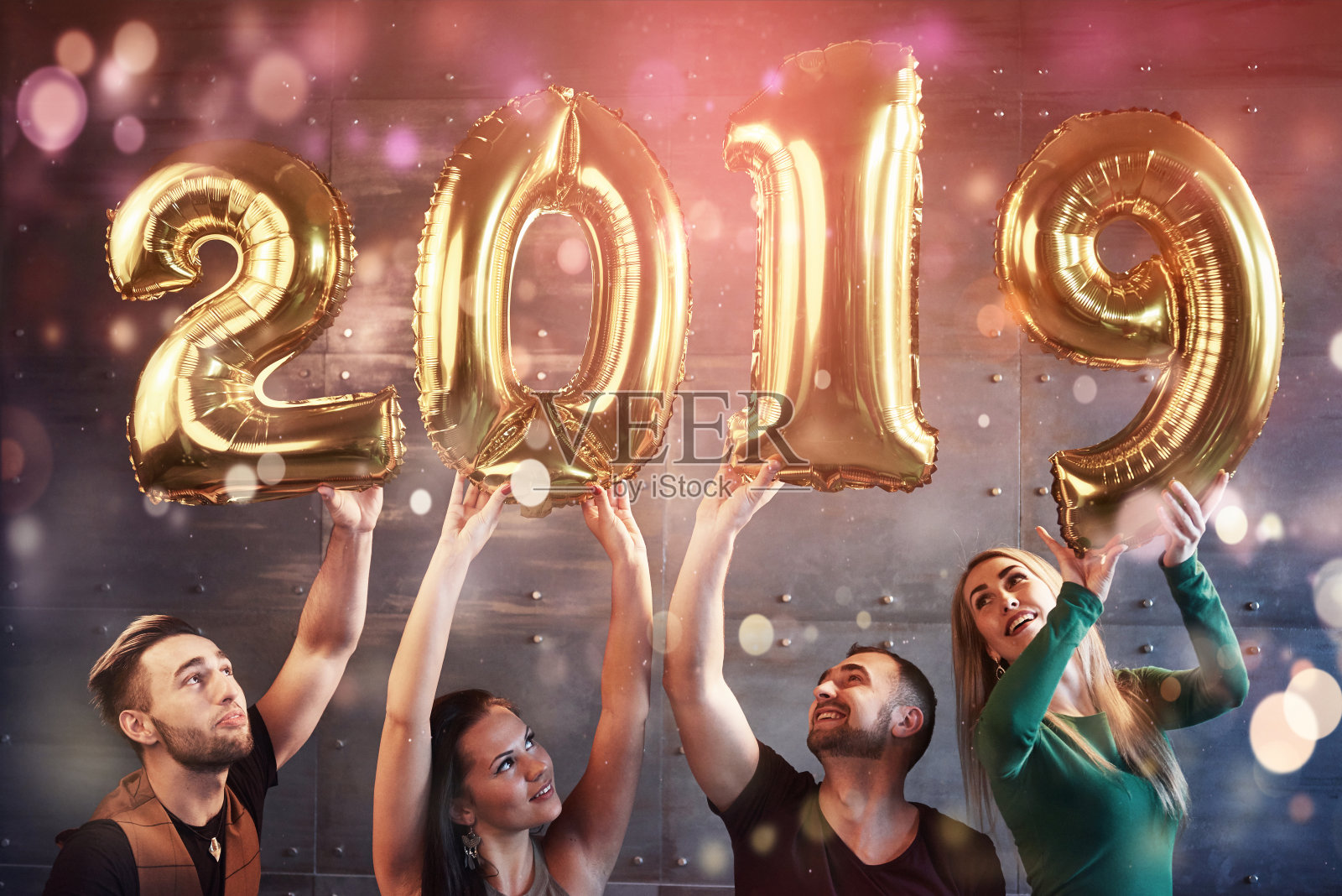 一群快乐的年轻人拿着数字，预示着2019年的到来。这个晚会是为了庆祝新年而举行的。关于青年团聚生活方式的概念照片摄影图片