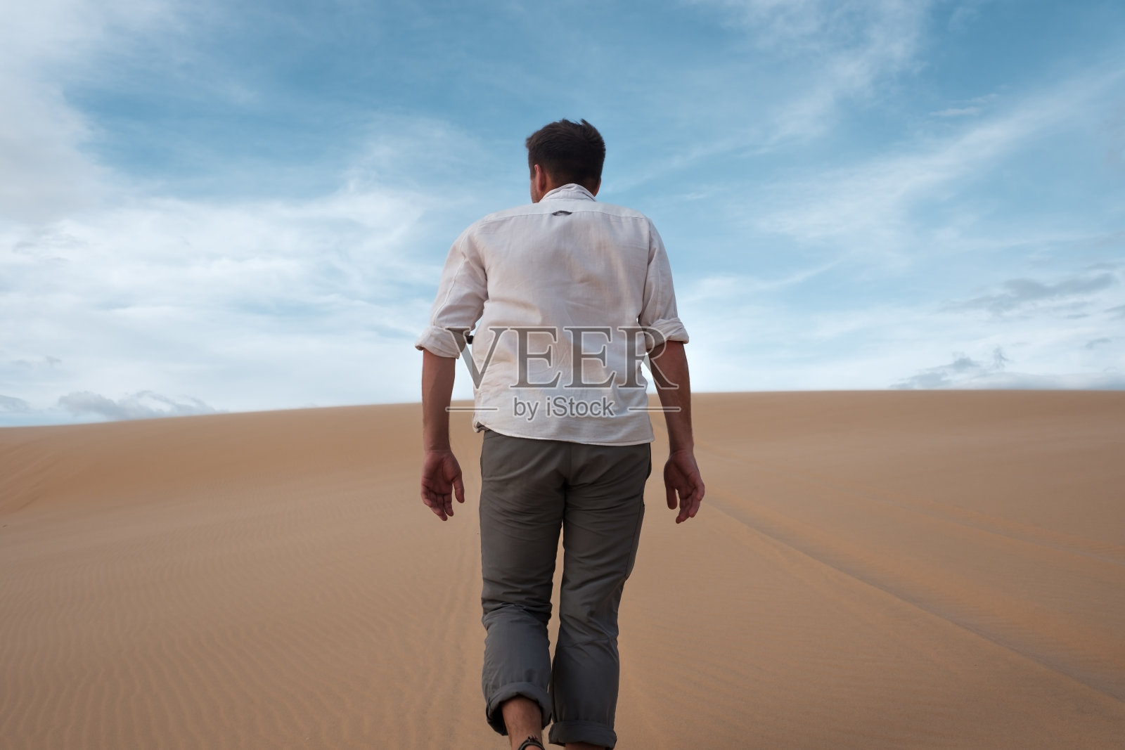 一个白人年轻人在沙漠里径直走着照片摄影图片