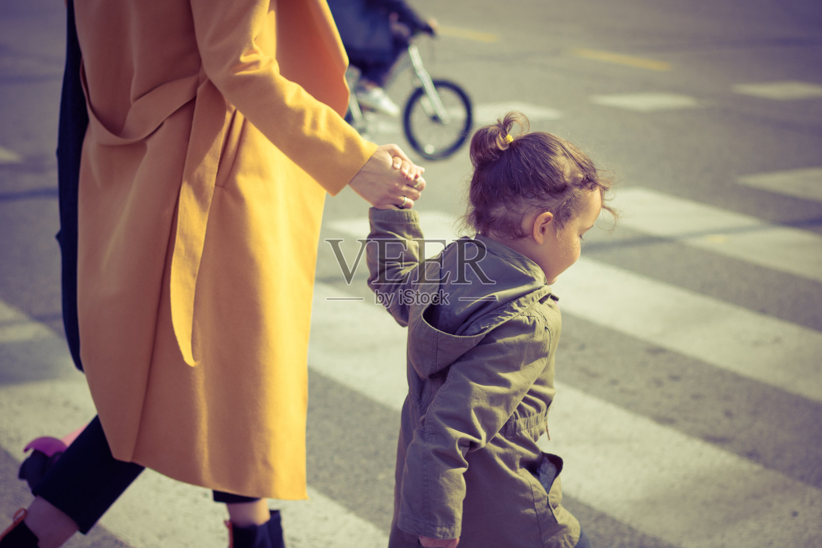 小女孩和妈妈一起过马路。照片摄影图片