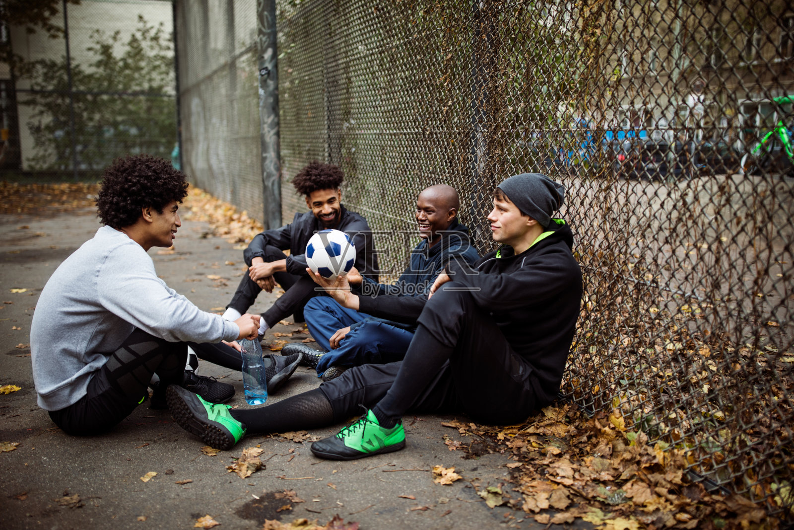 足球运动员们靠着围栏说话照片摄影图片