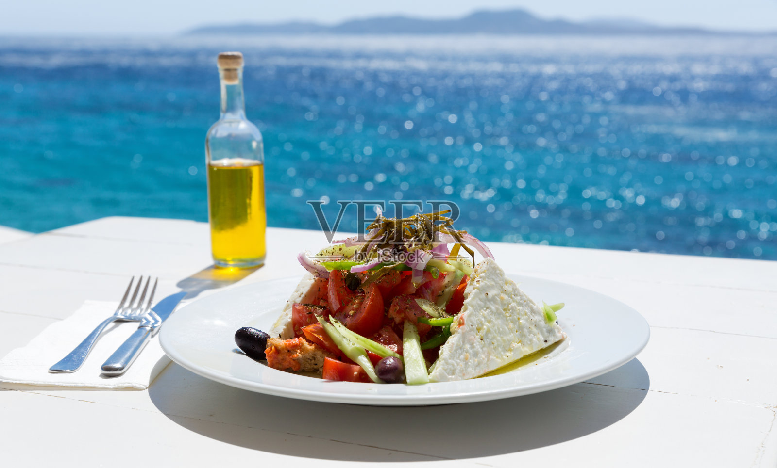 希腊沙拉和橄榄油瓶子照片摄影图片