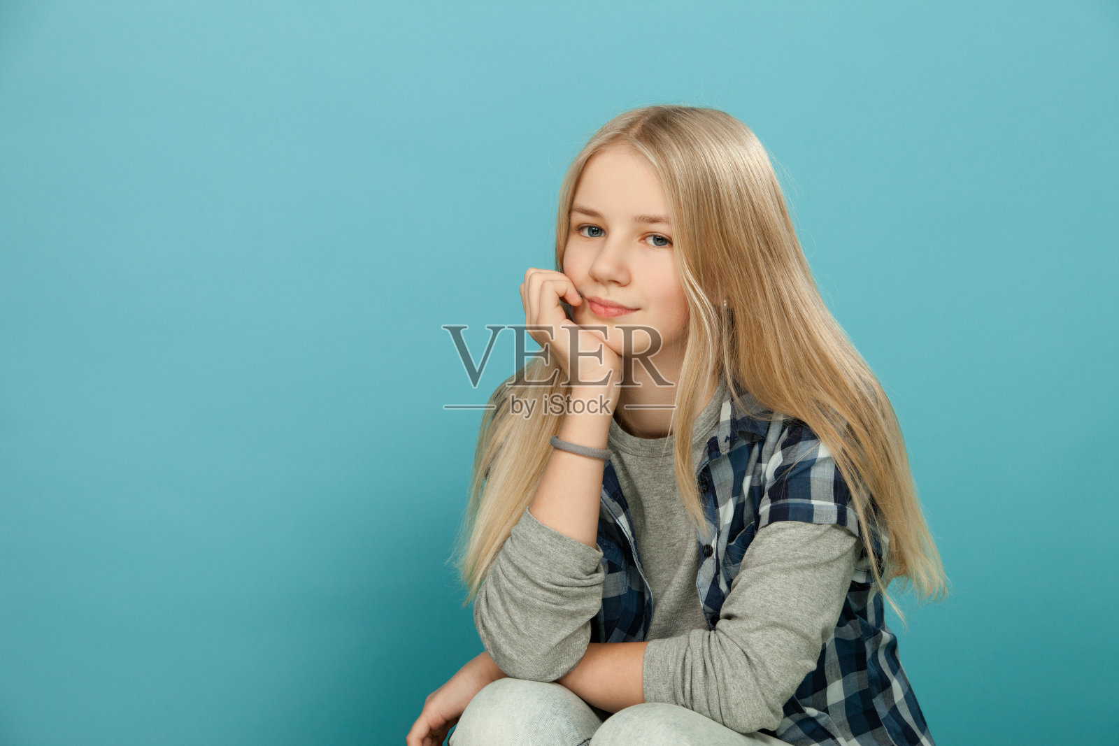 一个十几岁女孩的肖像在工作室的蓝色背景照片摄影图片