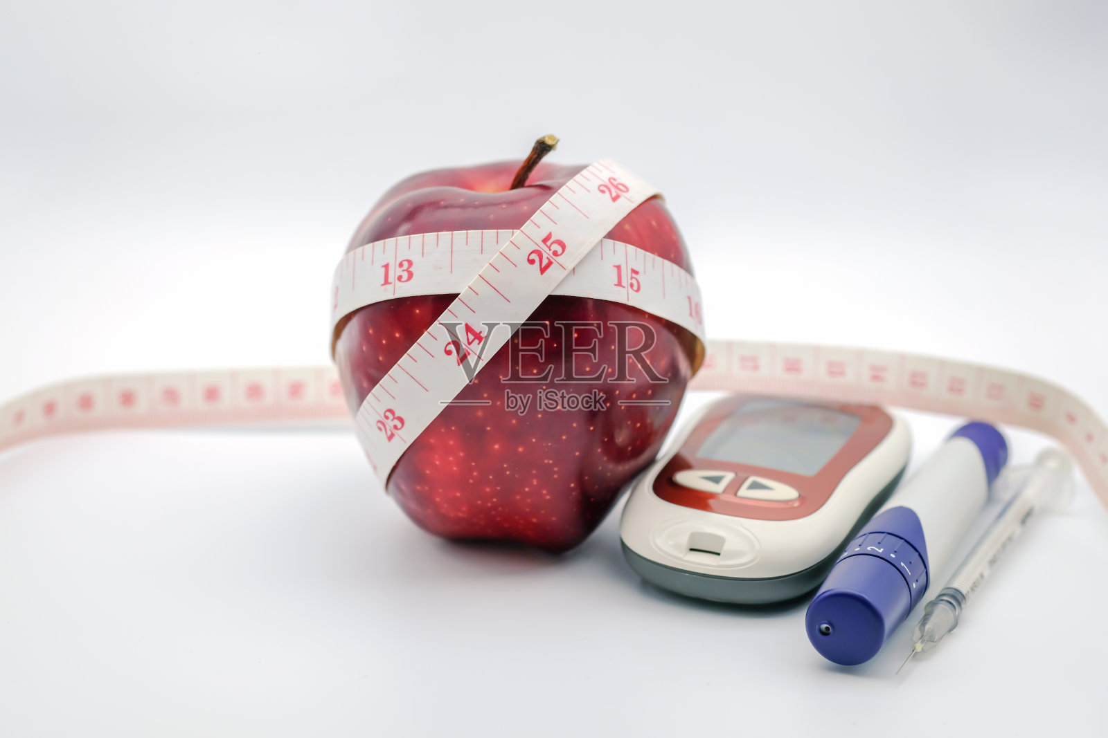 一个新鲜的红苹果，带测量尺，血糖仪，柳叶刀和胰岛素注射器，以检查和控制血糖水平。用作医药、糖尿病、降血糖、保健理念。照片摄影图片