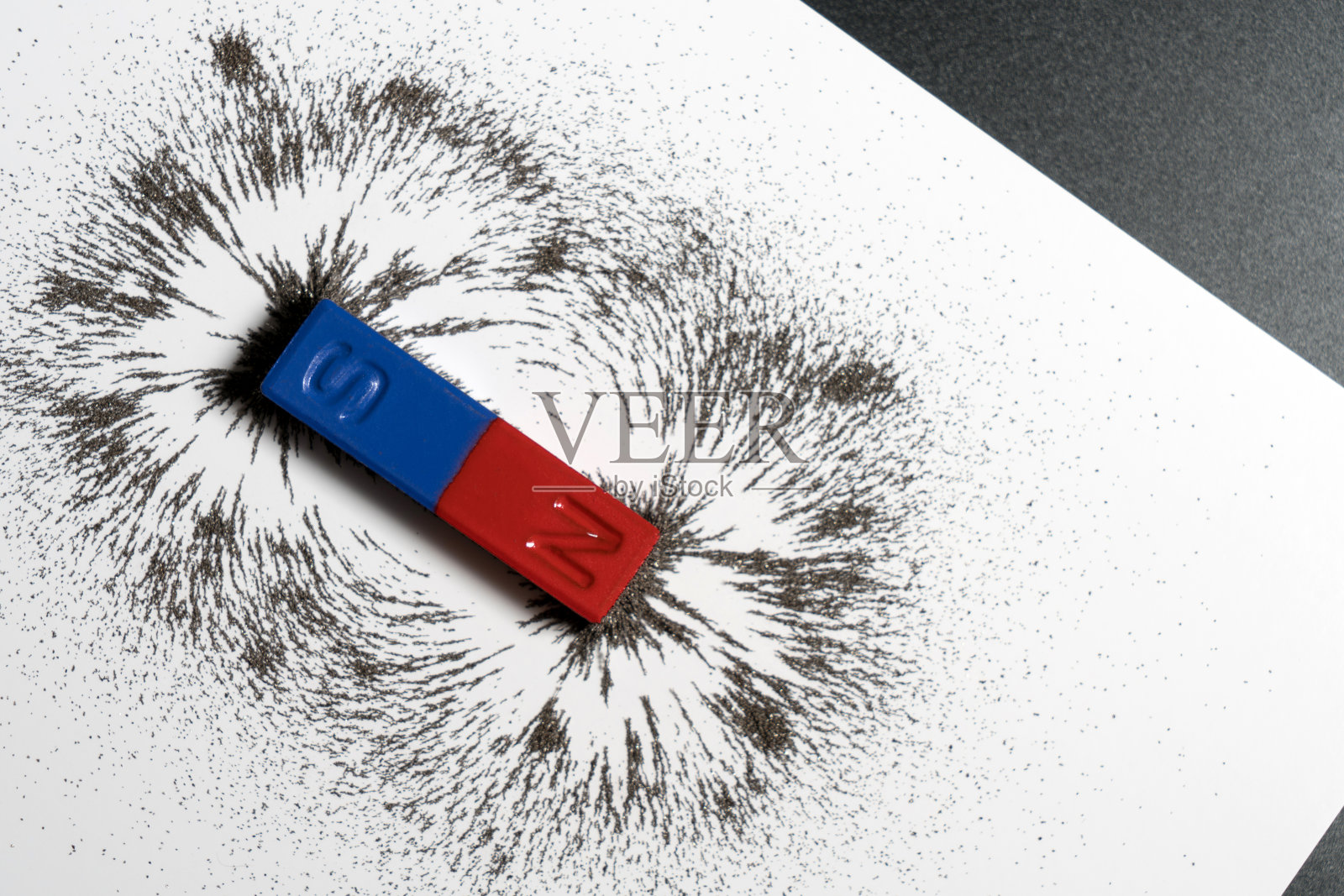 红色和蓝色棒状磁铁或物理磁性与铁粉磁场在白色背景。照片摄影图片