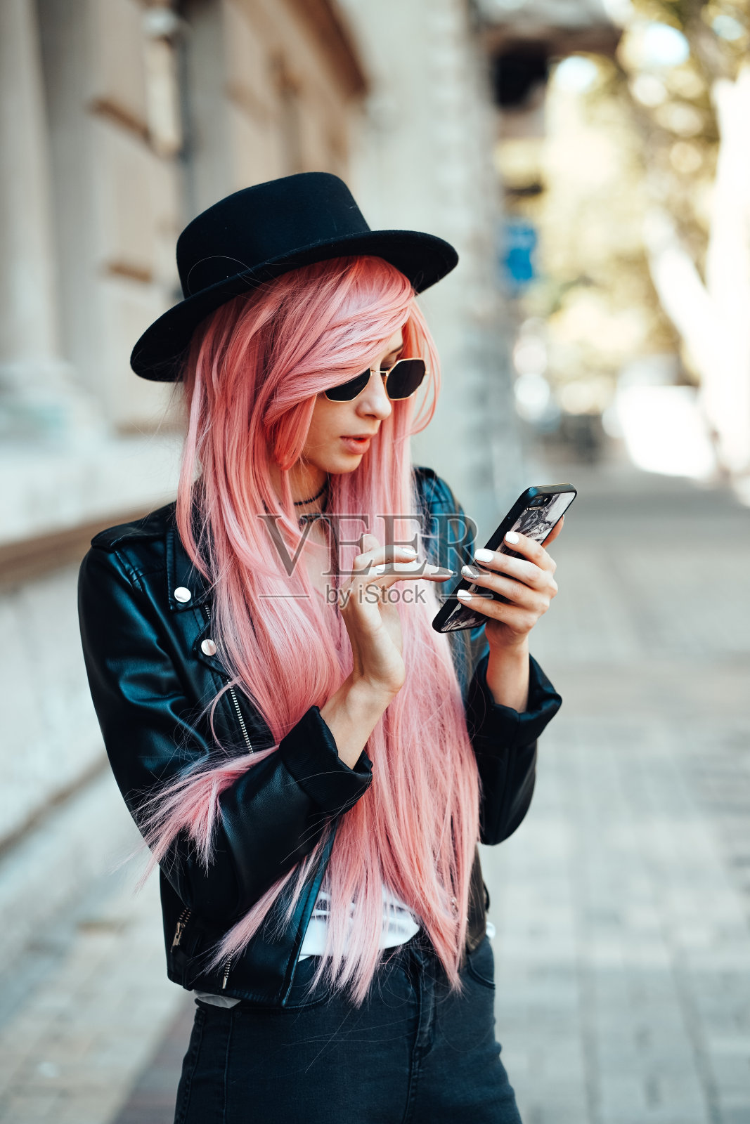 粉色头发拿着智能手机的女孩照片摄影图片
