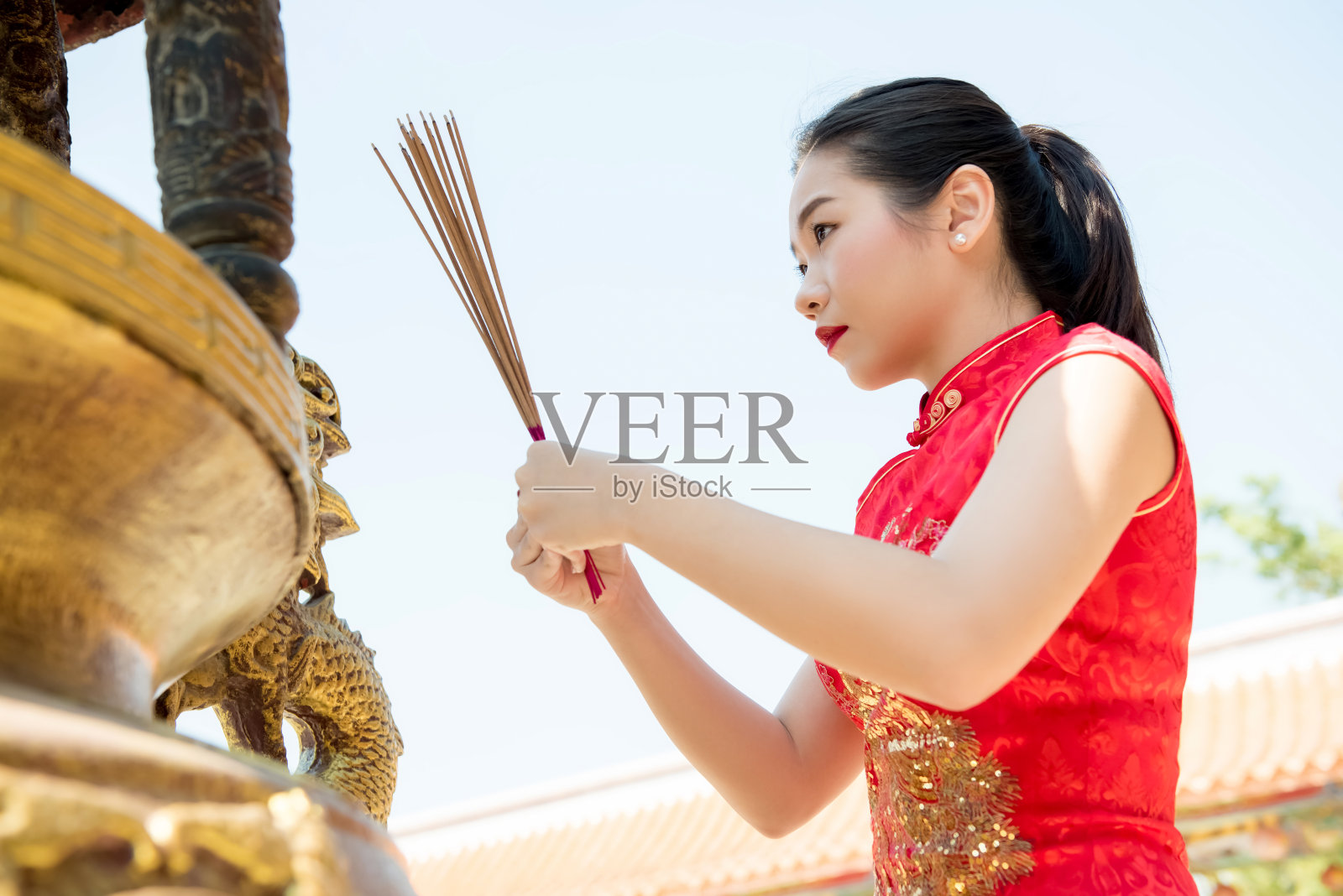 在中国新年期间用香烛祈祷的亚洲妇女照片摄影图片