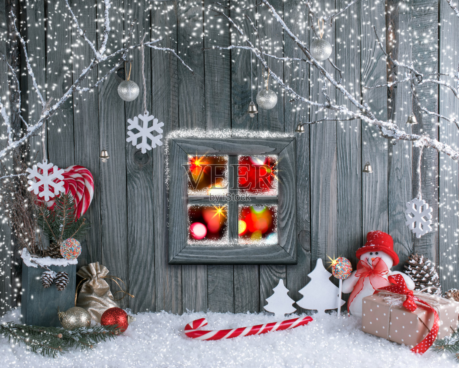 圣诞室内有雪人，窗户，装饰树枝，礼物和糖果拐杖在木板的背景。照片摄影图片