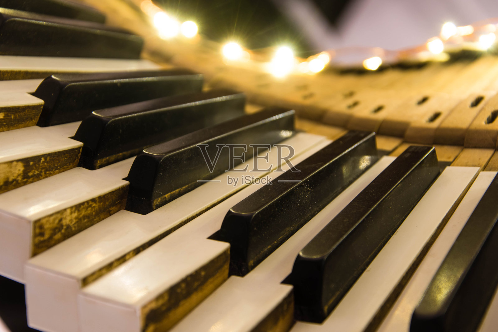 老式钢琴的键盘被向下推的键扭曲着照片摄影图片