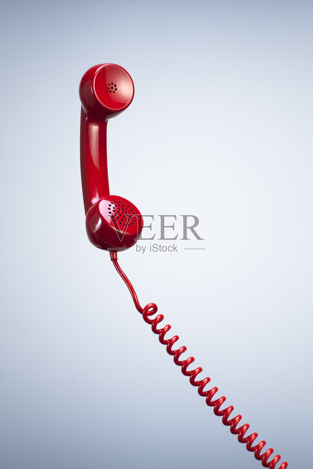 红色电话接收器与悬挂电缆隔离美丽的工作室背景。照片摄影图片