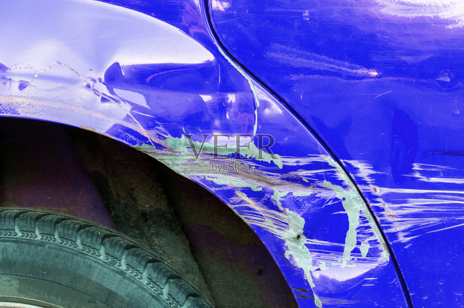 损坏的汽车。在车祸中或停车场中有油漆损坏的蓝色划痕车照片摄影图片