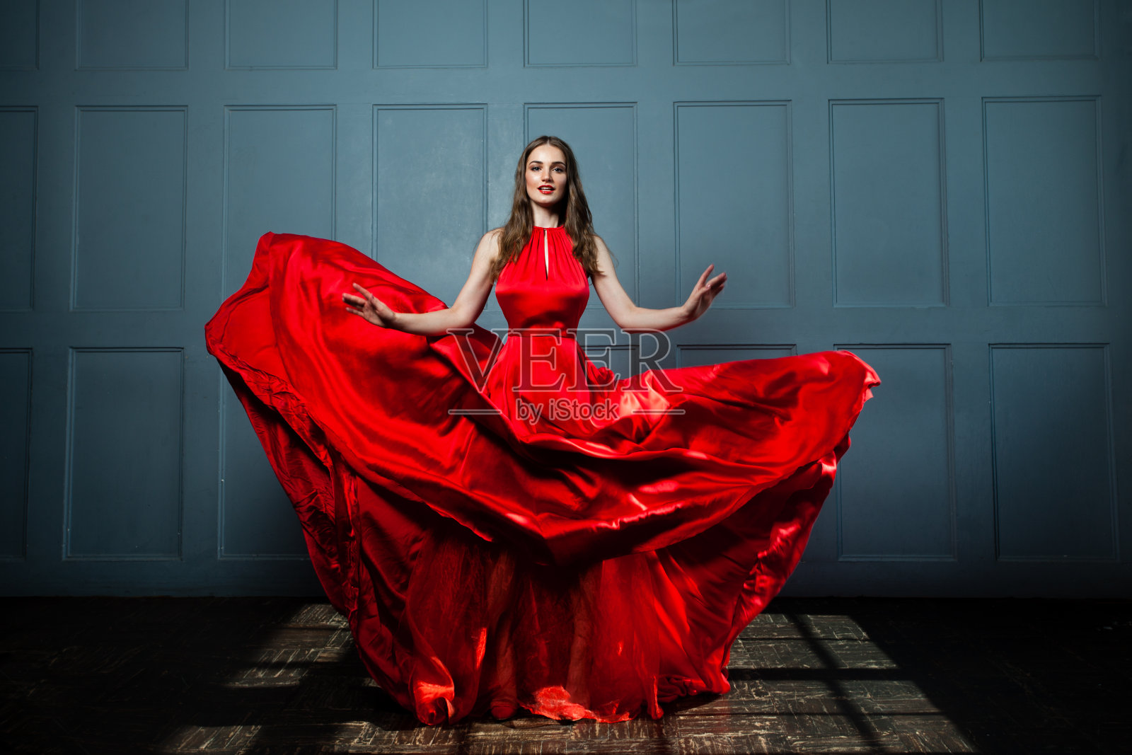 美丽的时装模特在红色丝绸连衣裙。美丽的女人，全貌照片摄影图片
