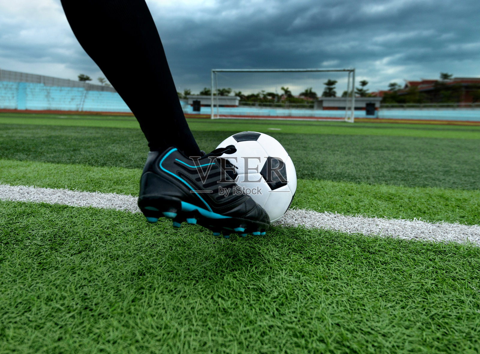 足球运动员用脚踢足球照片摄影图片