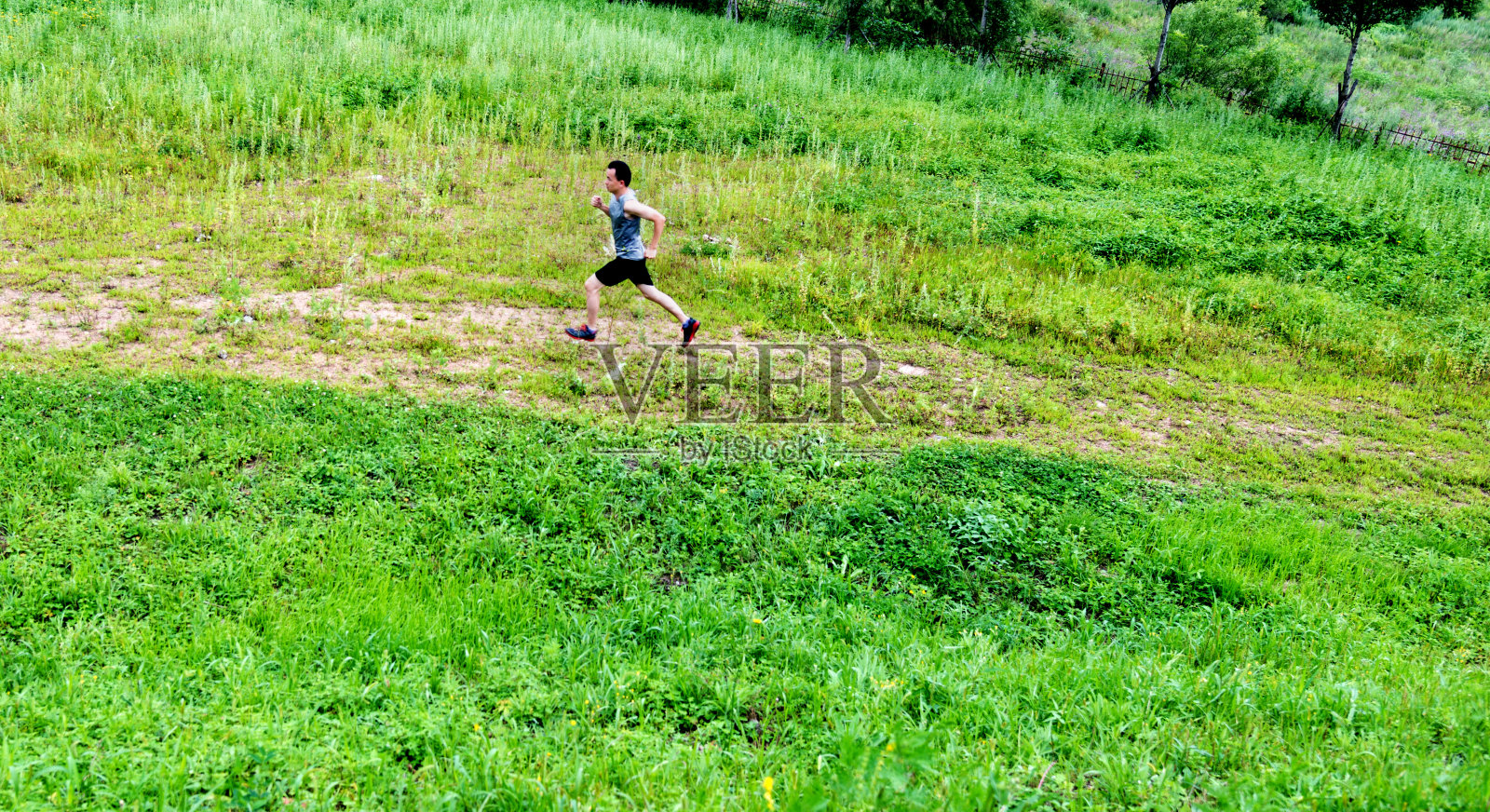 年轻人在草地上奔跑照片摄影图片