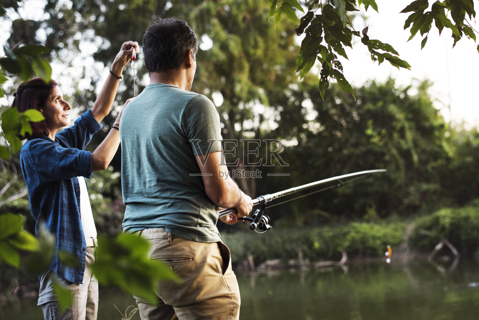 一对夫妇在丛林里钓鱼照片摄影图片