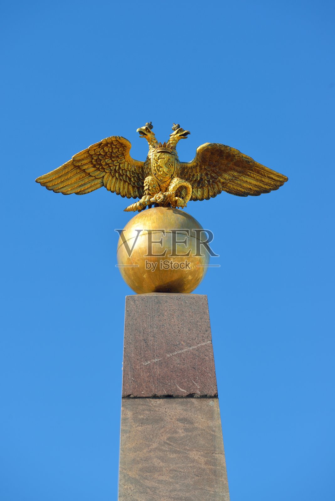 俄罗斯双头鹰。金色的建筑细节映衬着蓝天。照片摄影图片