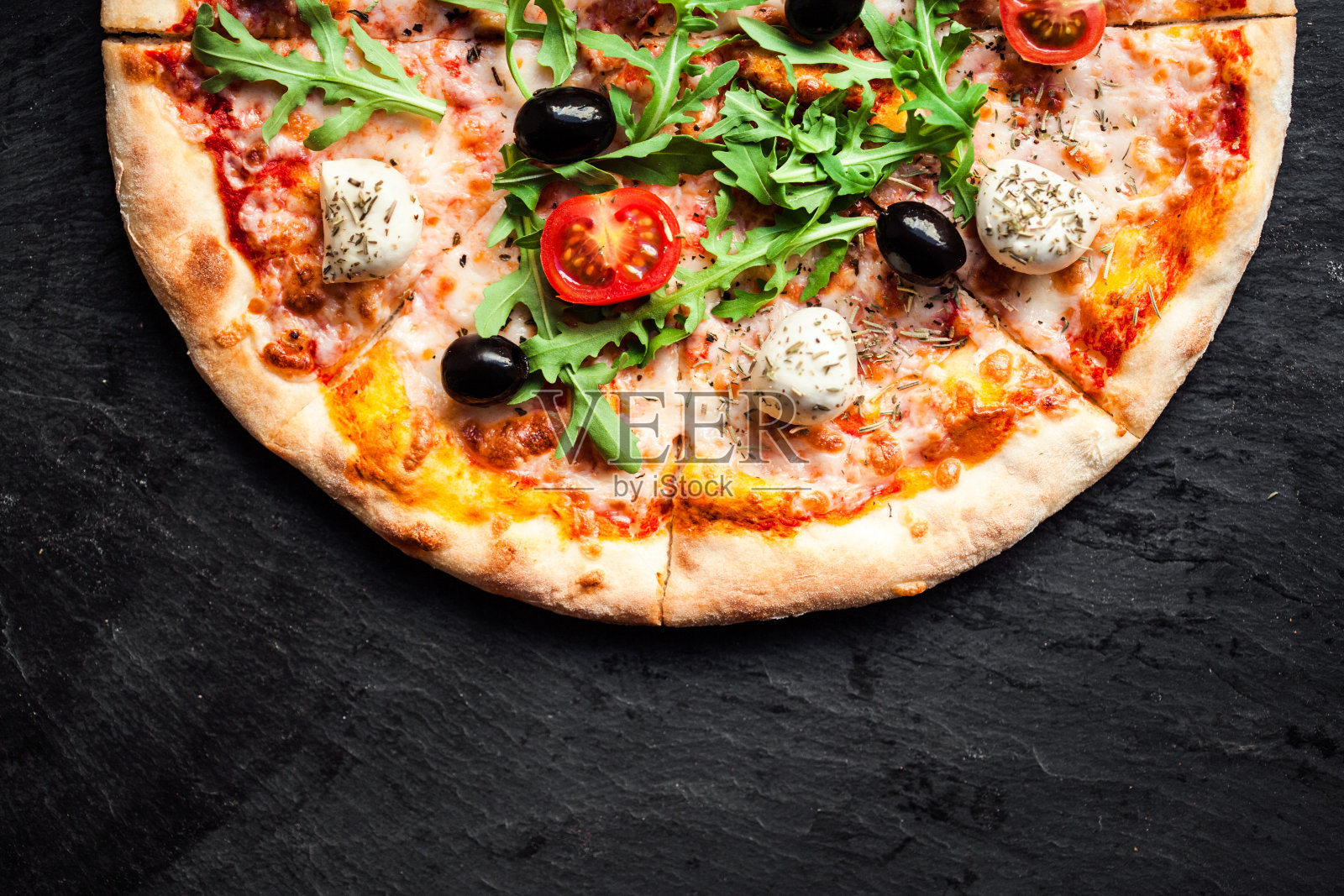 西红柿，马苏里拉奶酪和芝麻菜的披萨。比萨菜单。顶部视图与复制空间在深色的石头桌子照片摄影图片