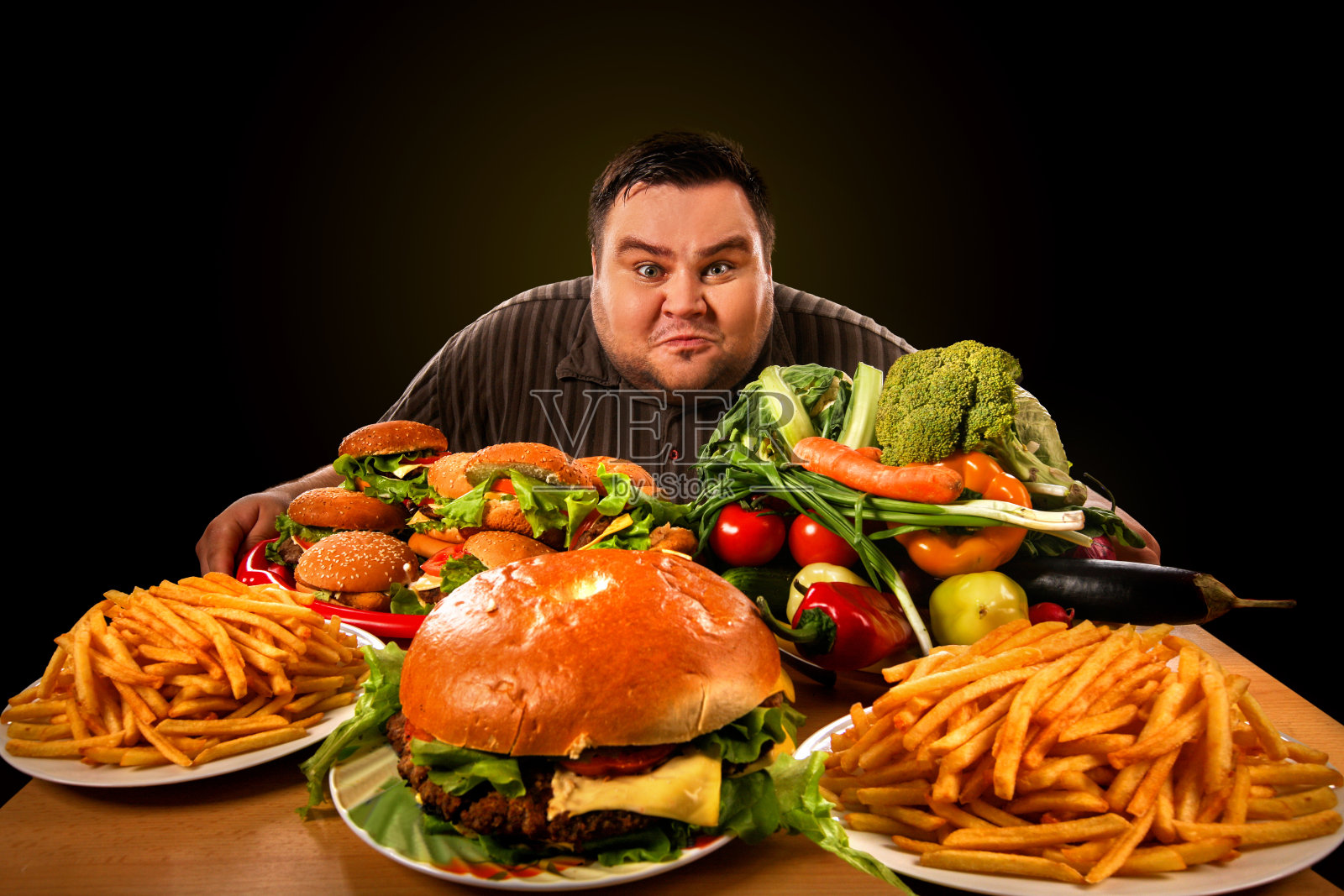饮食肥胖的人在健康和不健康的食物之间做出选择。照片摄影图片