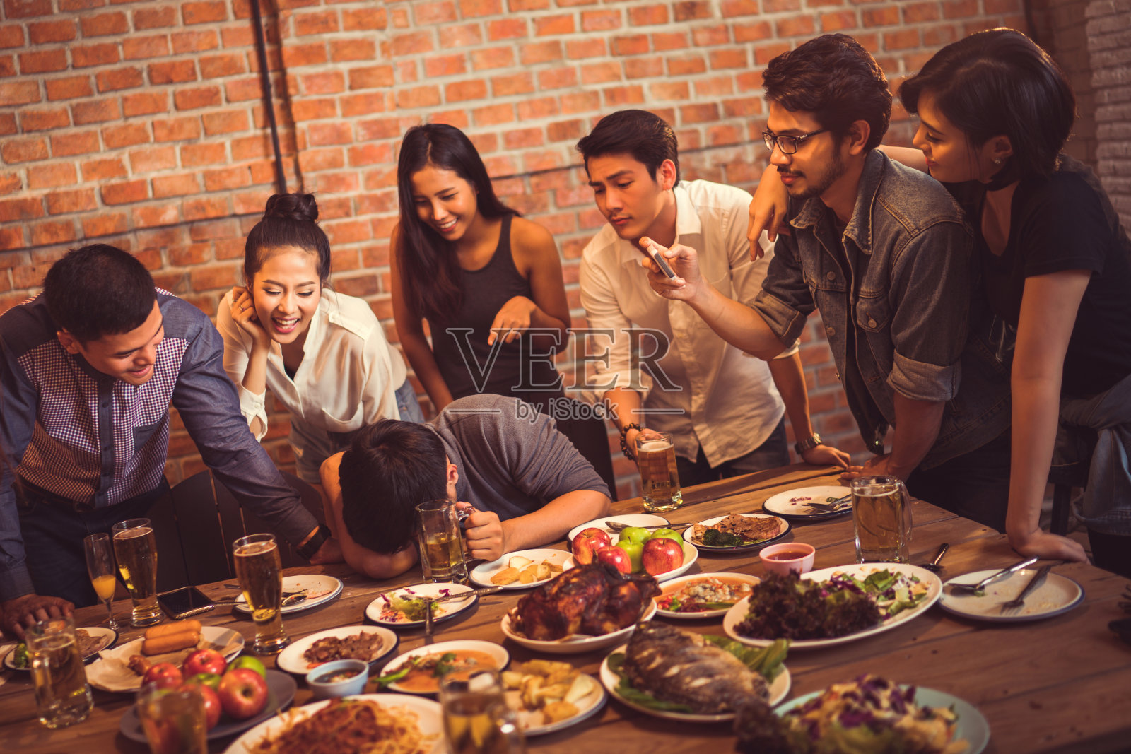 一群朋友在拍照，因为喝亚洲人而喝醉的人。照片摄影图片