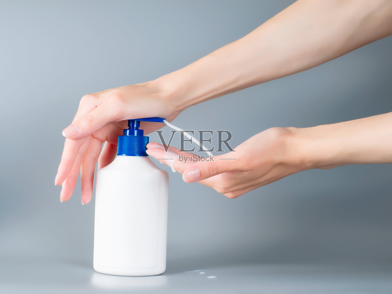 女人用双手将肥皂液从自动售货机中倒出来照片摄影图片