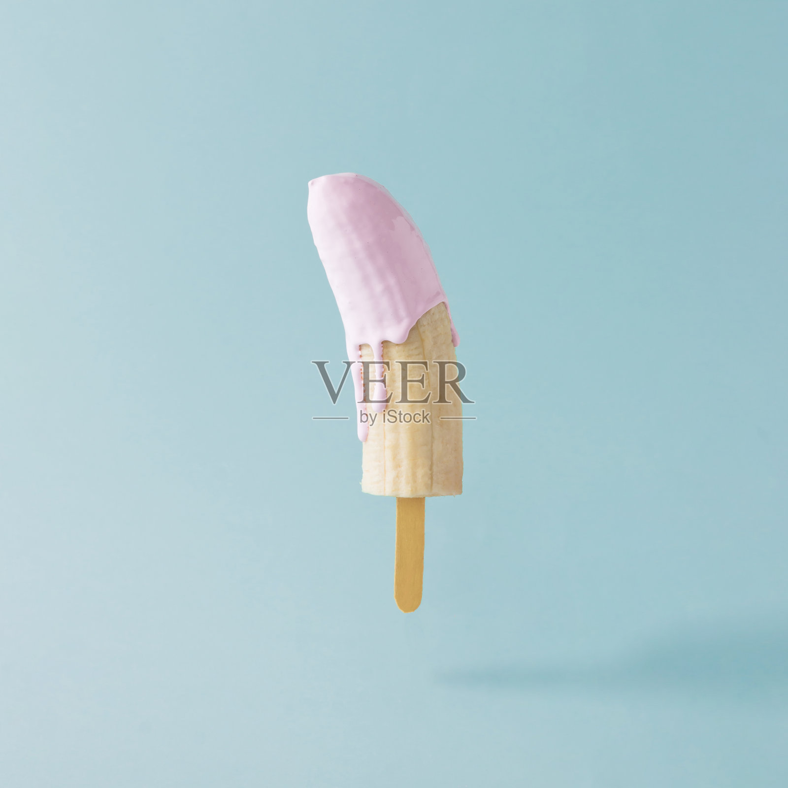 淡蓝色背景上的香蕉和冰淇淋棒。食品创意概念。照片摄影图片