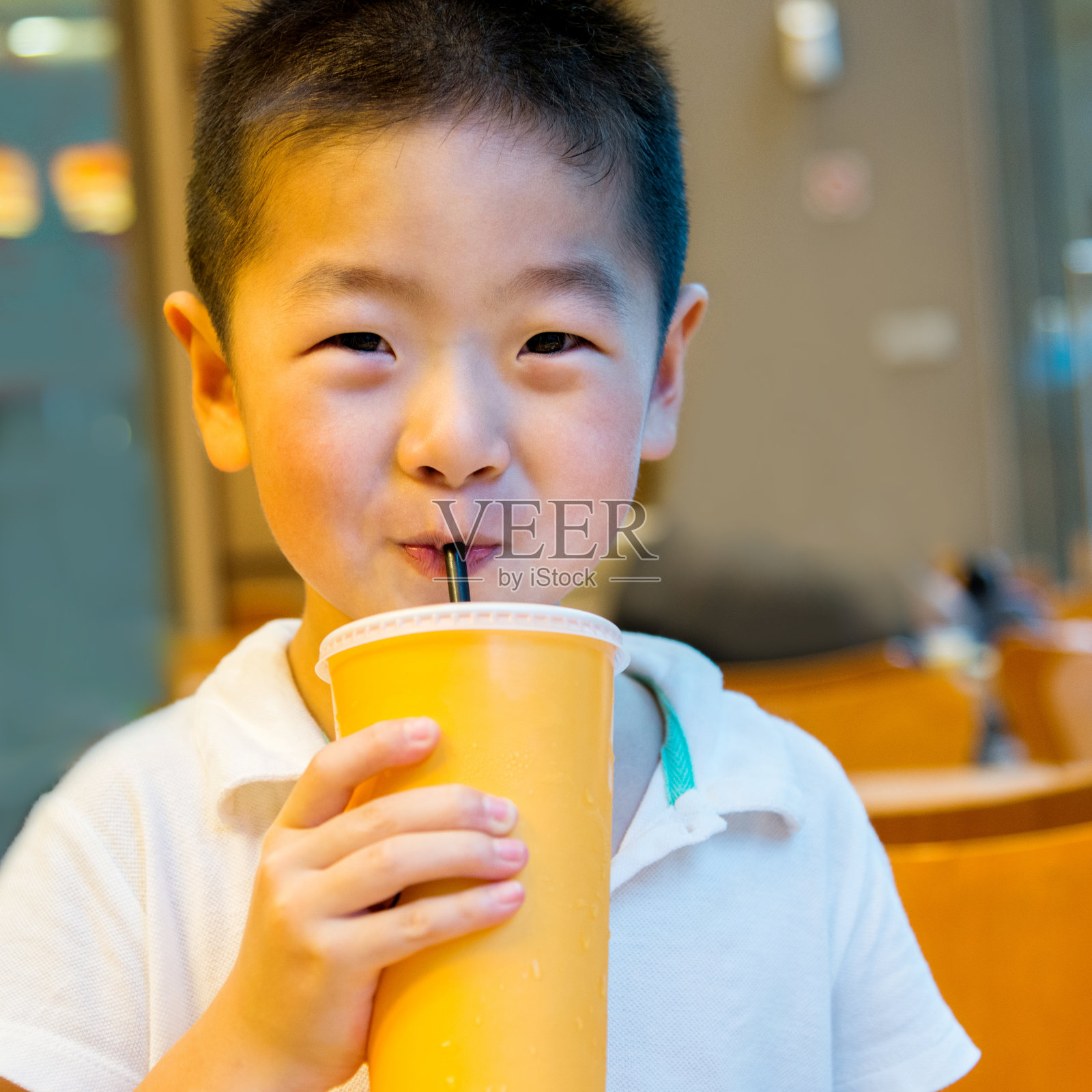 小男孩用吸管喝果汁照片摄影图片