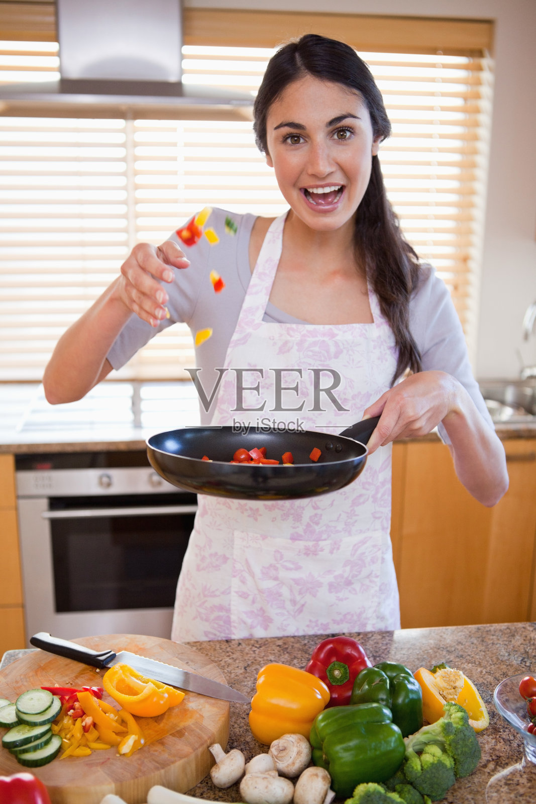 一个正在准备一道菜的快乐女人的肖像照片摄影图片