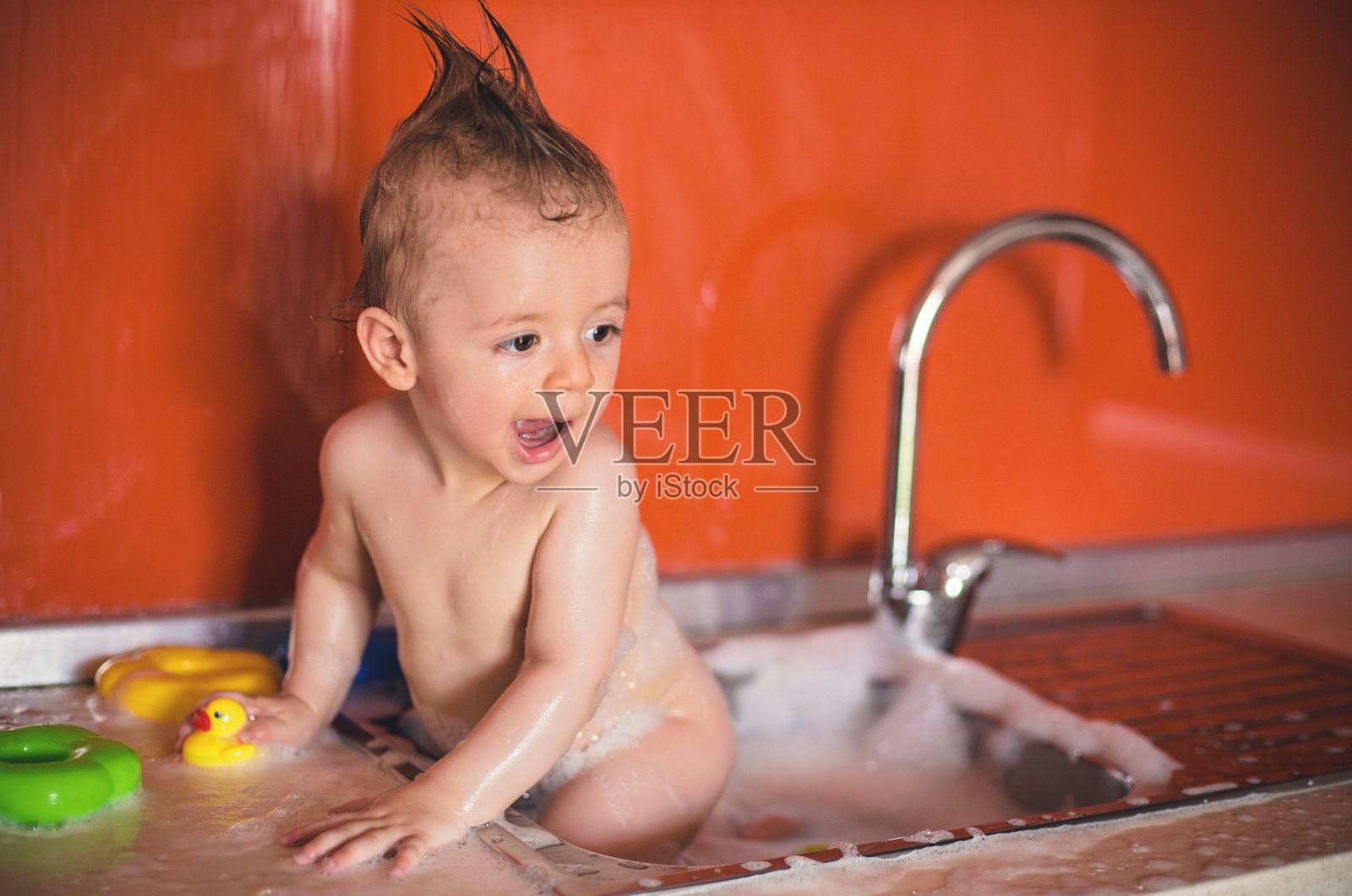 可爱的小男孩在水槽洗澡照片摄影图片