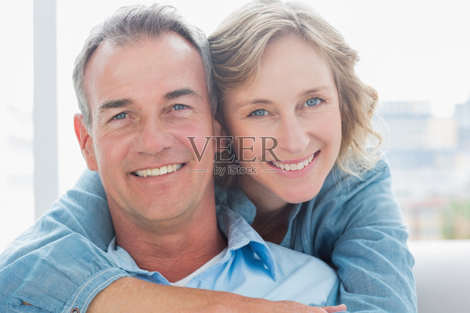 微笑的女人从后面拥抱她的丈夫照片摄影图片