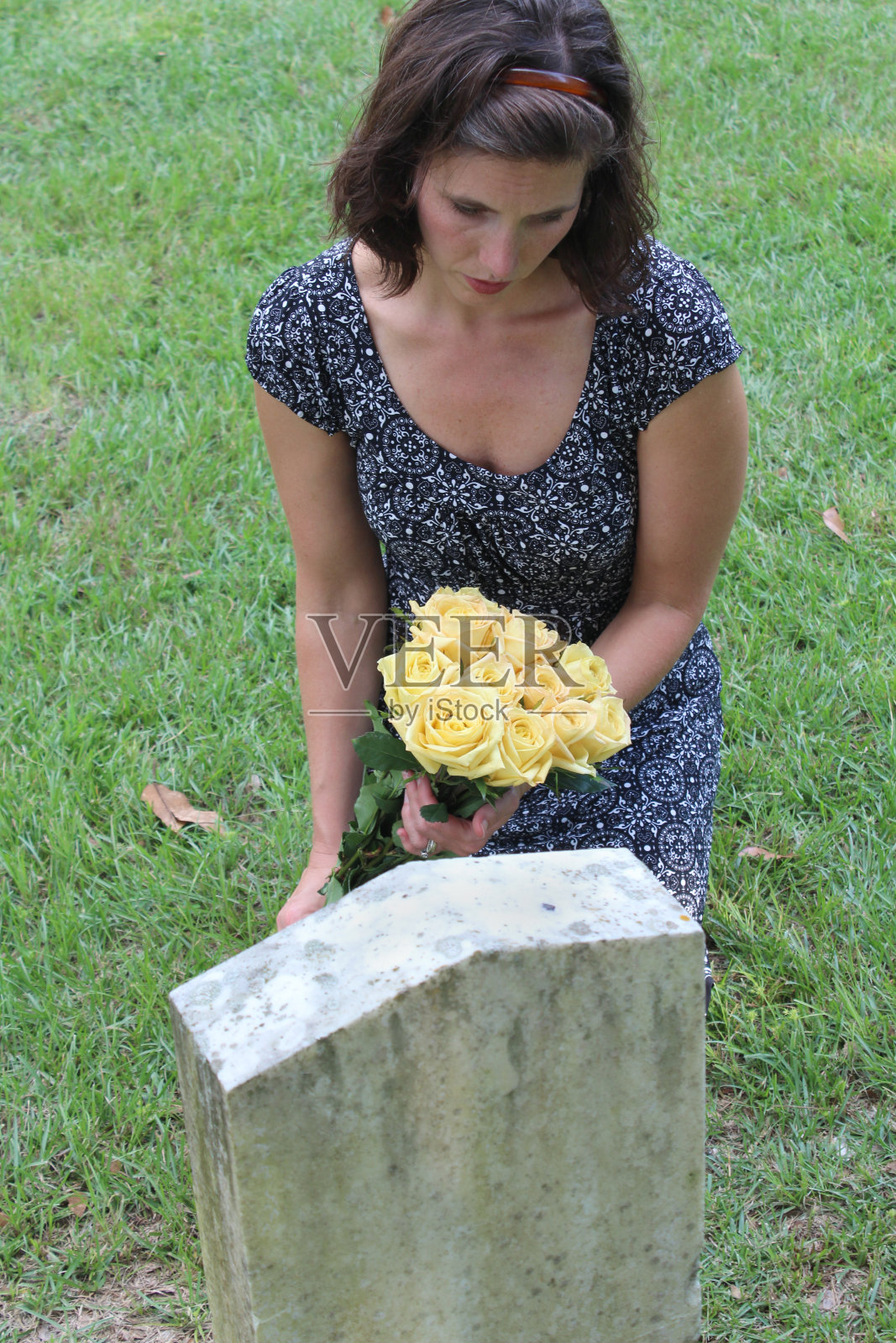 女人在坟墓上放花照片摄影图片