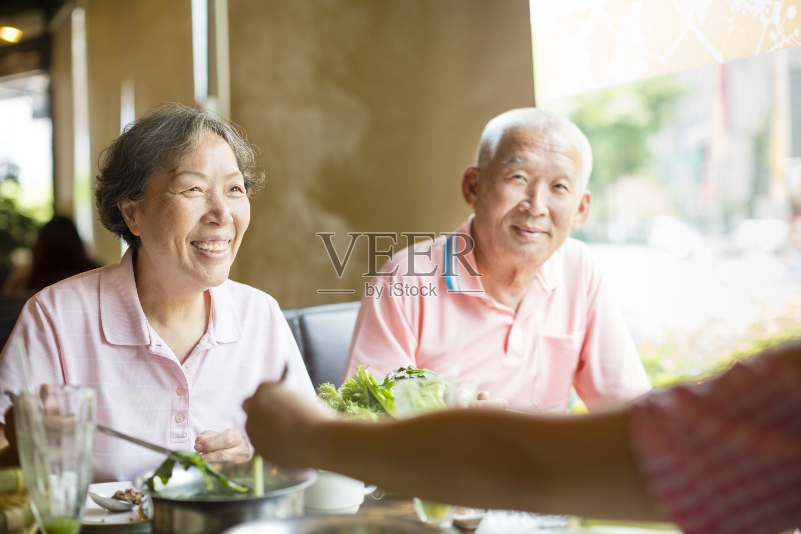 一对老年夫妇和家人在饭店吃火锅照片摄影图片