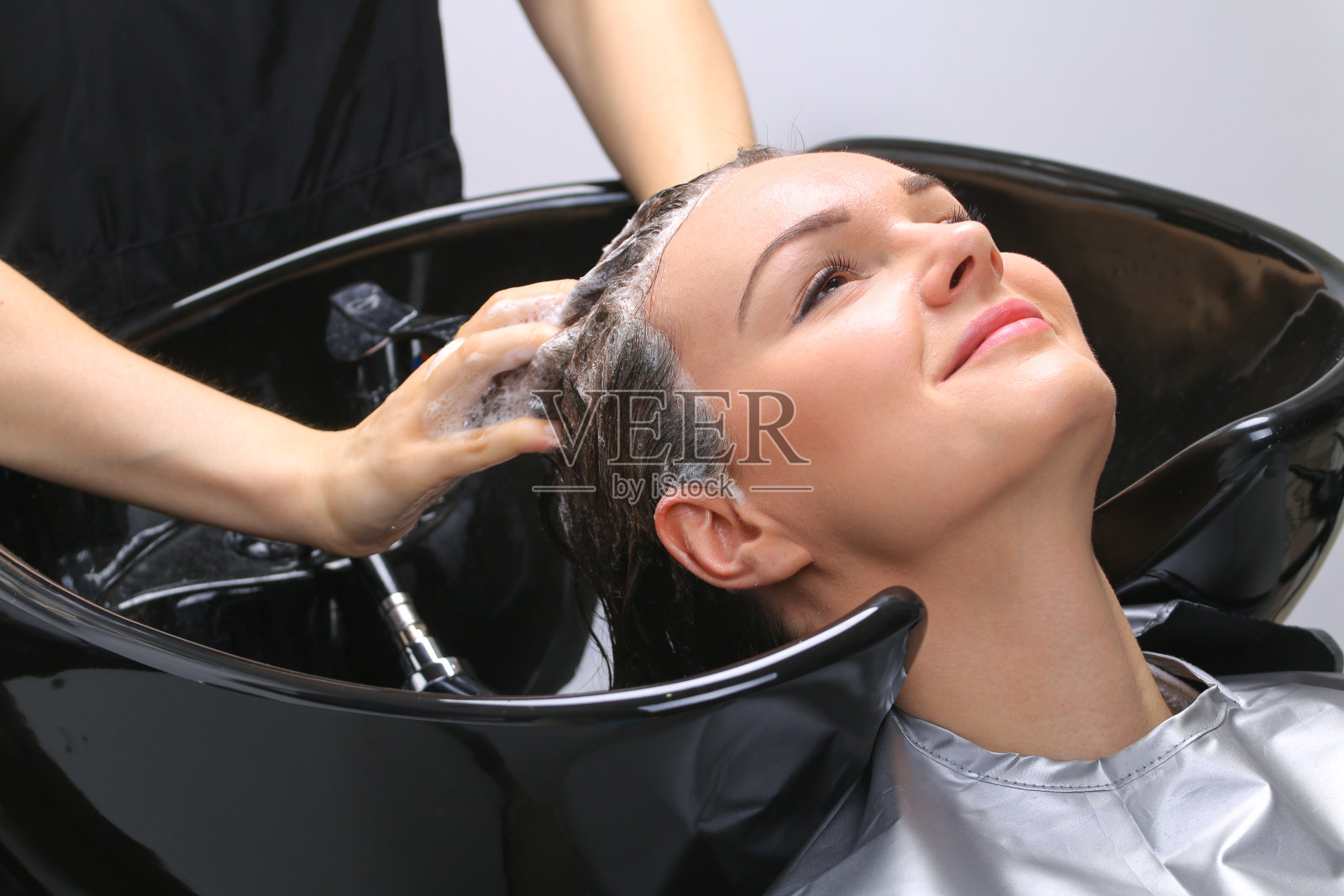 美发师在美发厅为一位女士洗头照片摄影图片