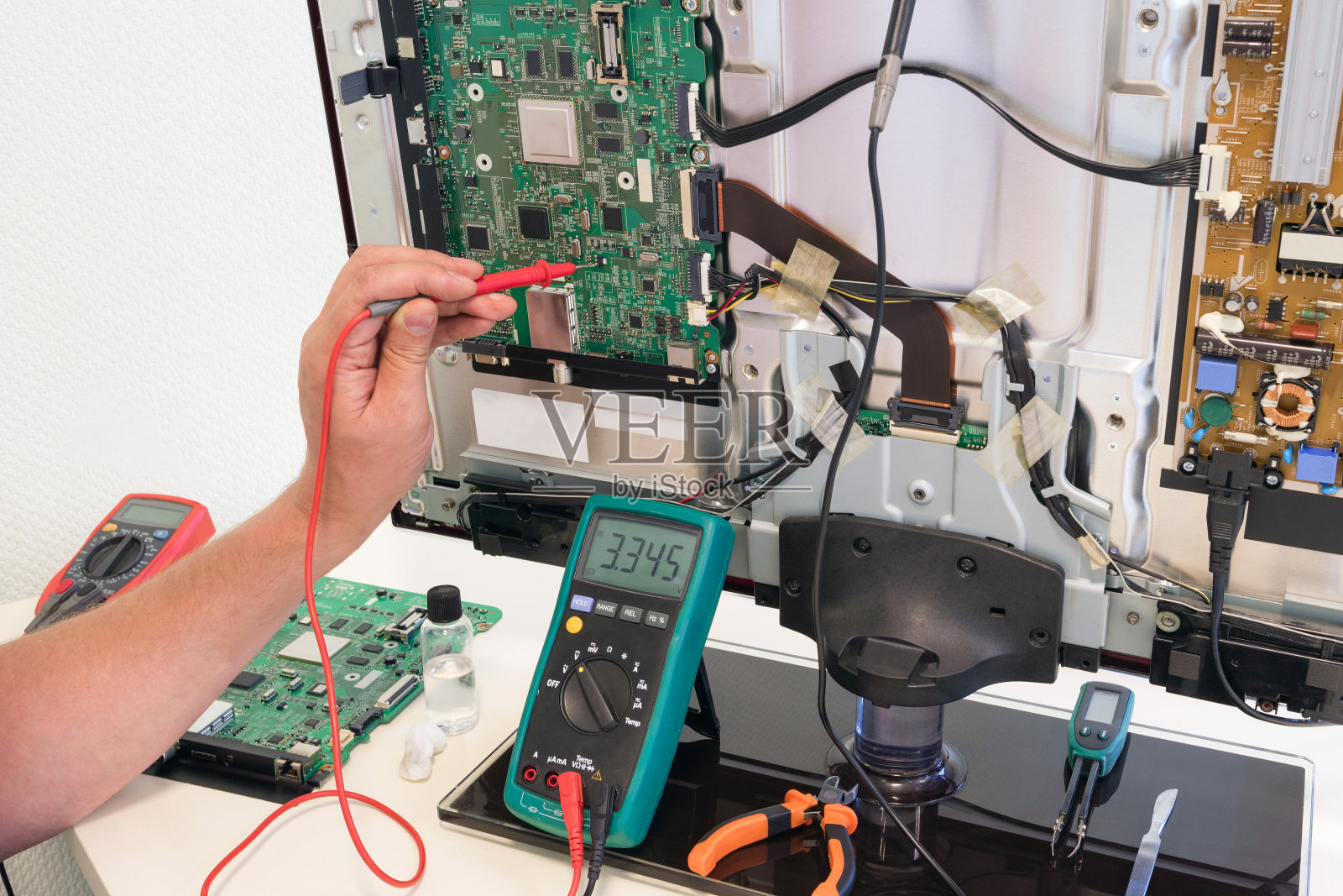 消费电子维修工程师测量电视板上的电压照片摄影图片