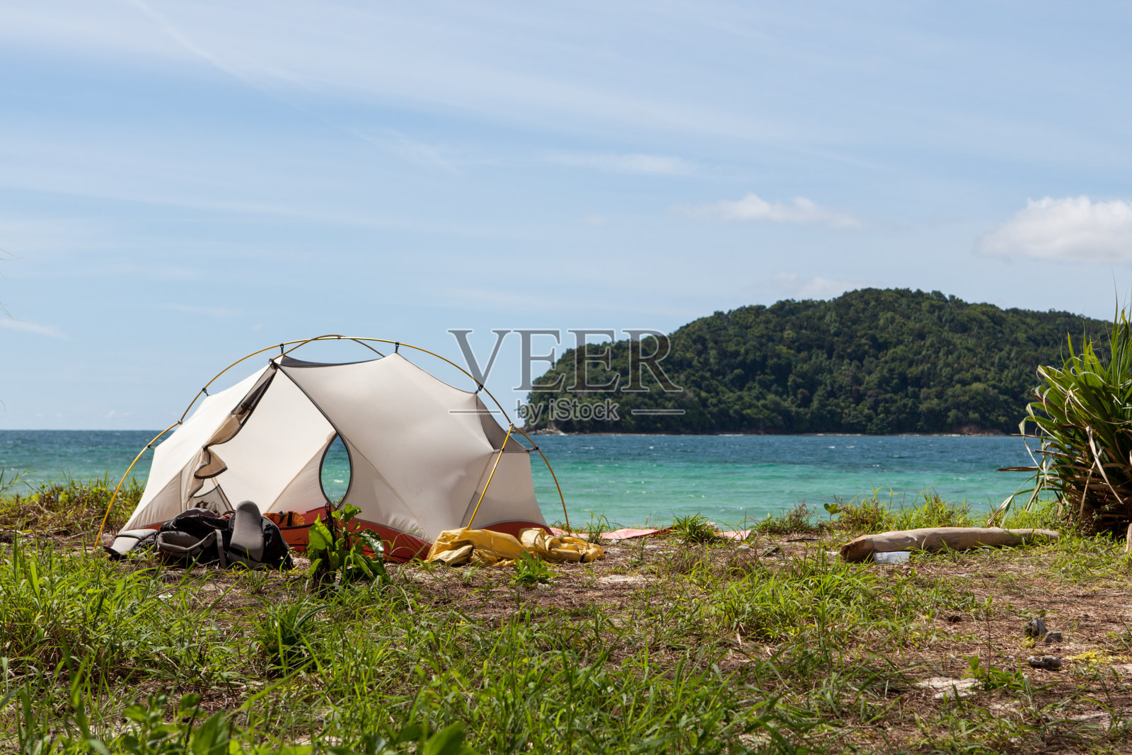 在一个无人岛的海滩上露营。热带丛林景观，蓝色的海水和天堂般的海滩露营。异国情调的海滩露营地点。照片摄影图片