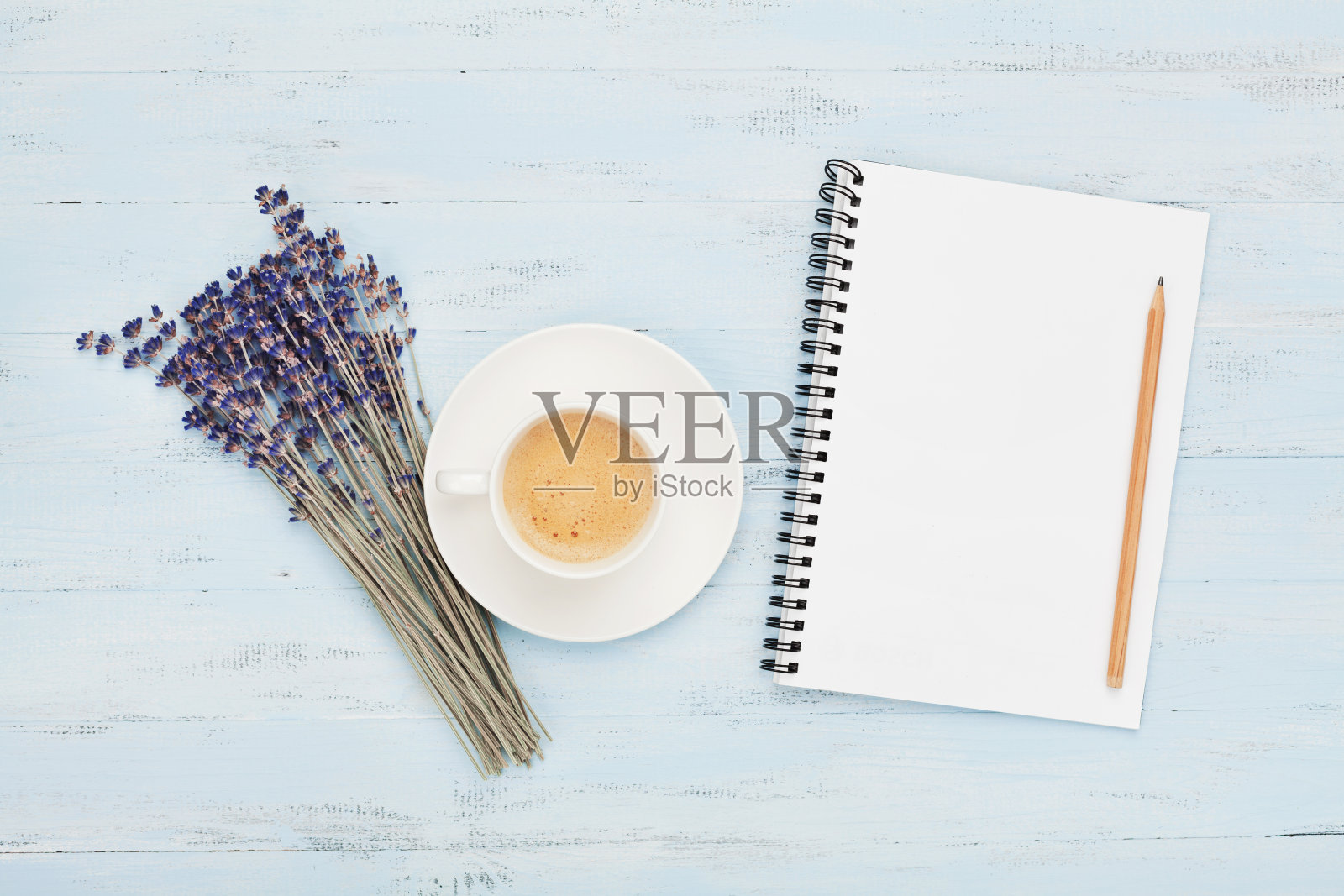 一杯咖啡，空笔记本和薰衣草花在蓝色的桌子上顶视图。女人工作的办公桌。温馨的早餐。照片摄影图片