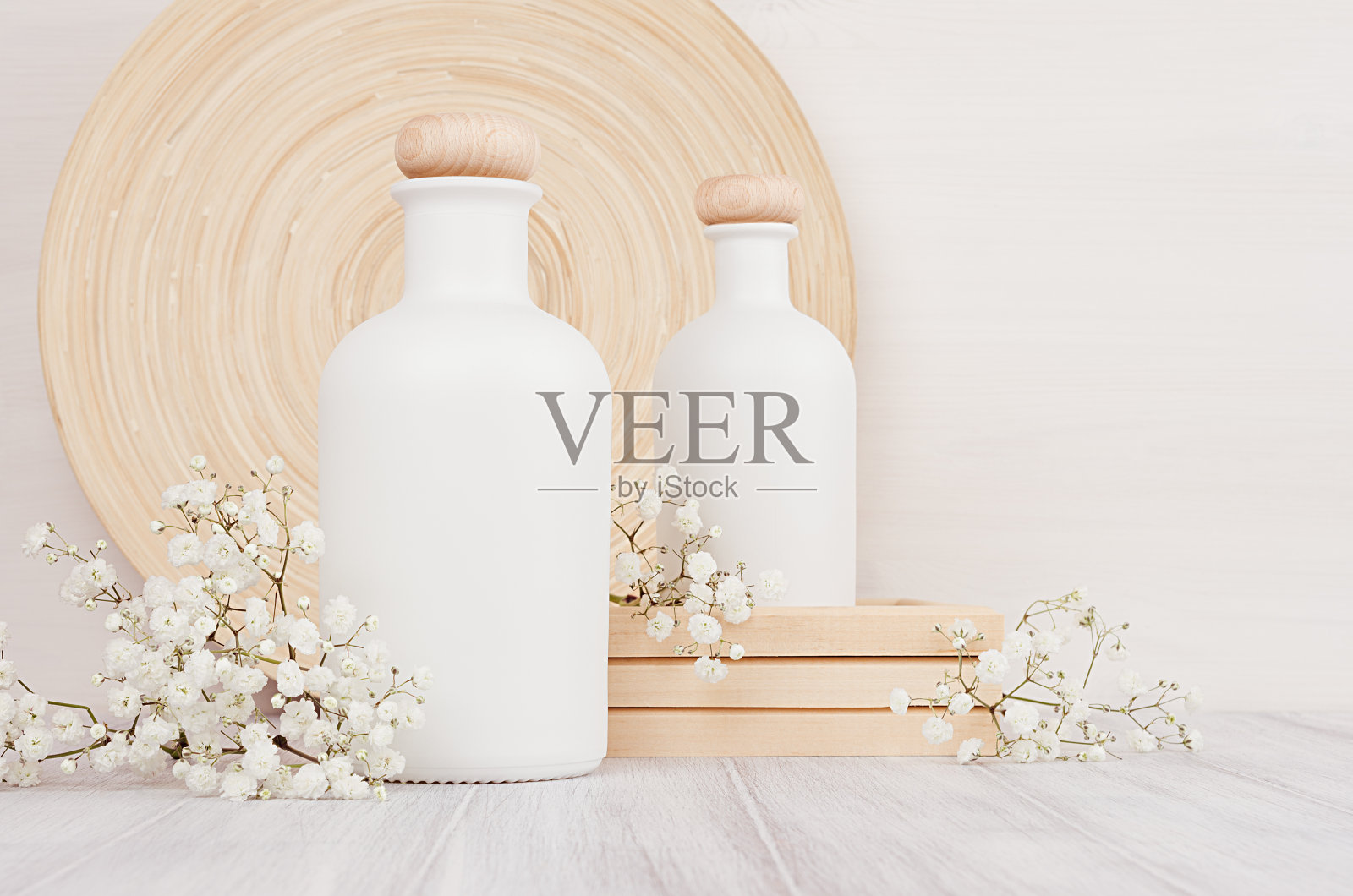 空白白色化妆品瓶与小花在白色木板，复制空间，模拟。照片摄影图片