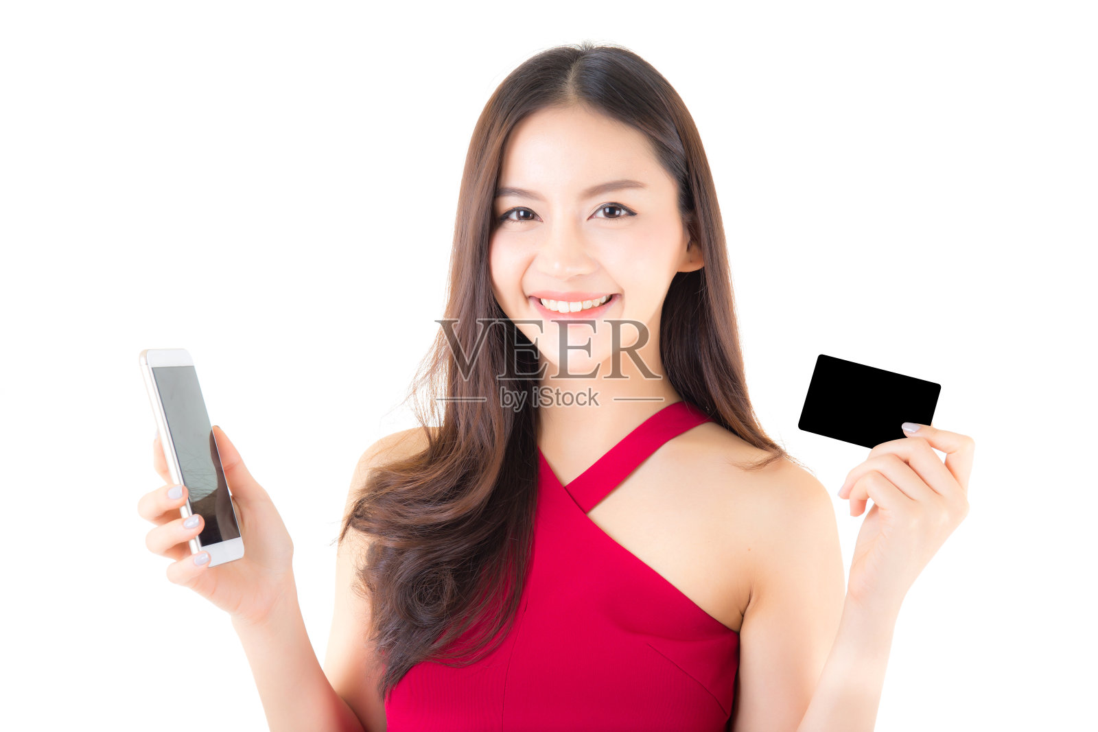 开朗的亚洲年轻女子与电话和信用卡在白色的背景，网上购物的概念。照片摄影图片