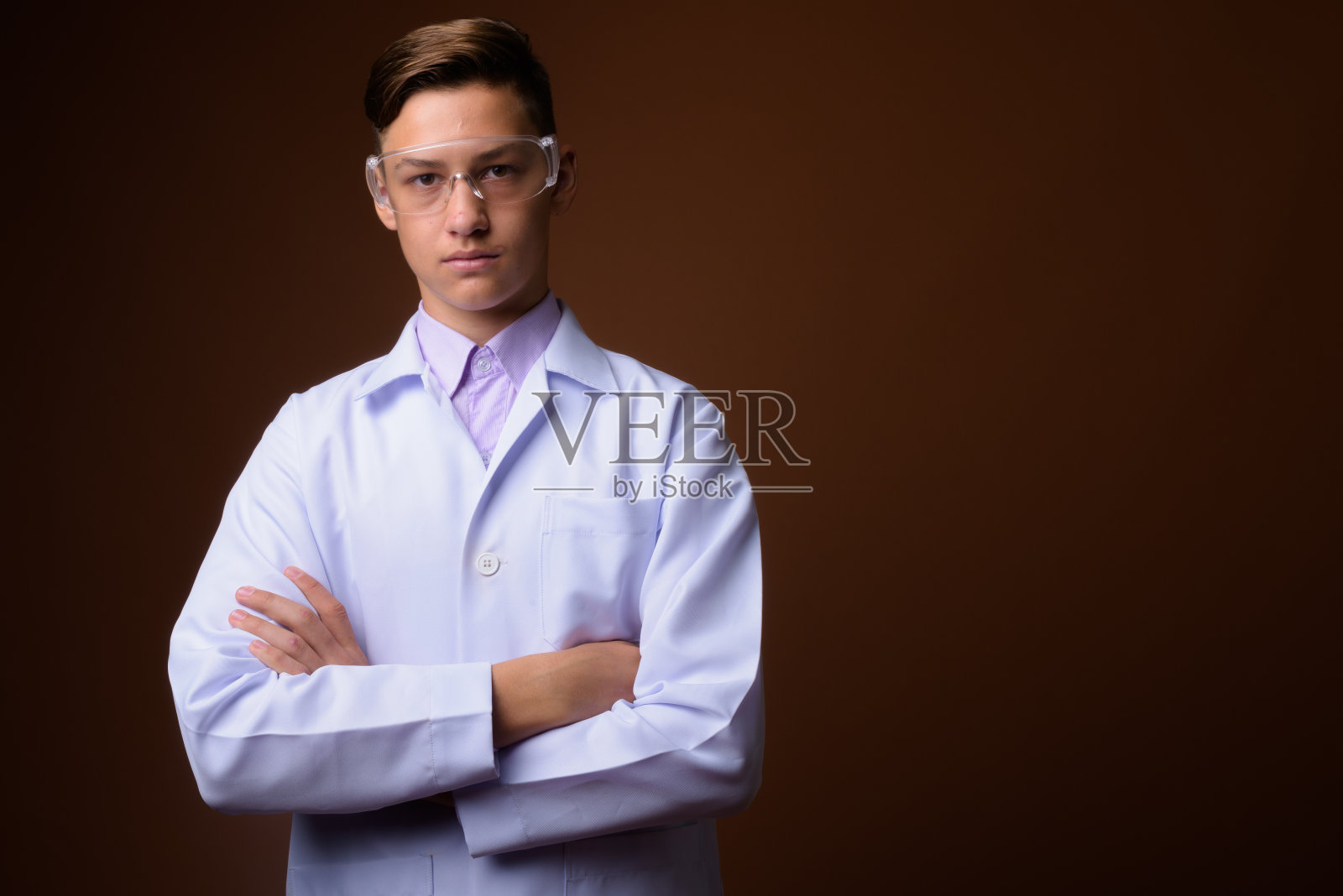 工作室拍摄的年轻英俊的医生戴着保护眼镜，反对彩色背景照片摄影图片
