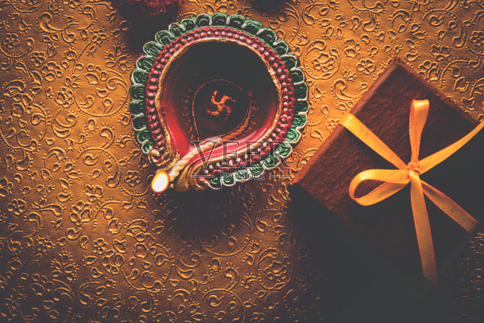 库存照片美丽的排灯节diwali diya与礼物和鲜花，在装饰背景，穆迪照明和选择性焦点照片摄影图片